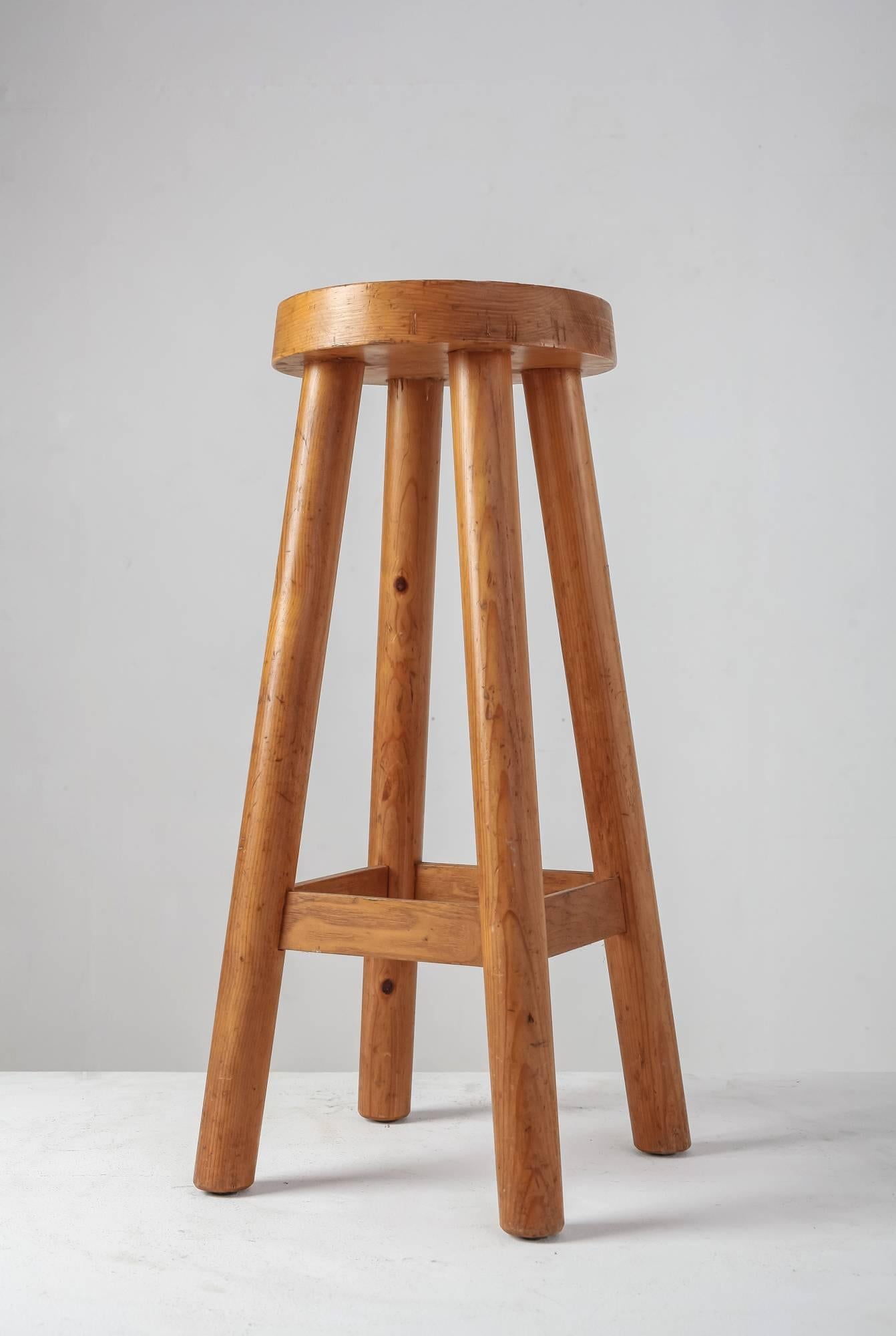 A very rare high pine bar stool in the Campagne style with four legs, by Charlotte Perriand. The round seating has a diameter of 28.5 cm (11