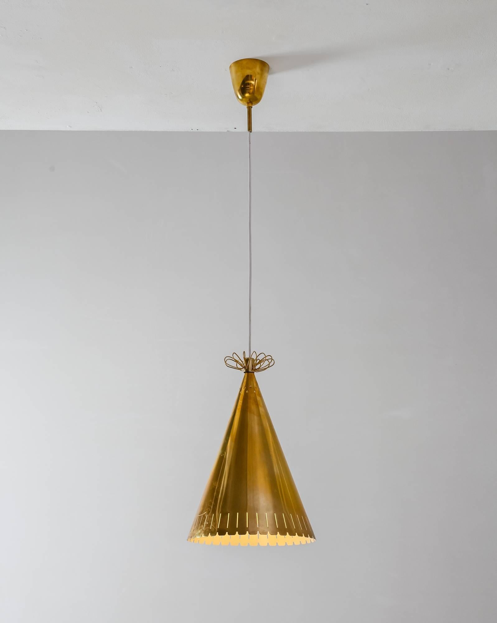 A Paavo Tynell cone shaped brass pendant with serrated edges vertical and round perforations and a brass decoration op top. This model was likely custom-made for a hotel in Turku, Finland.
The measurements stated are of the shade.

* This piece is