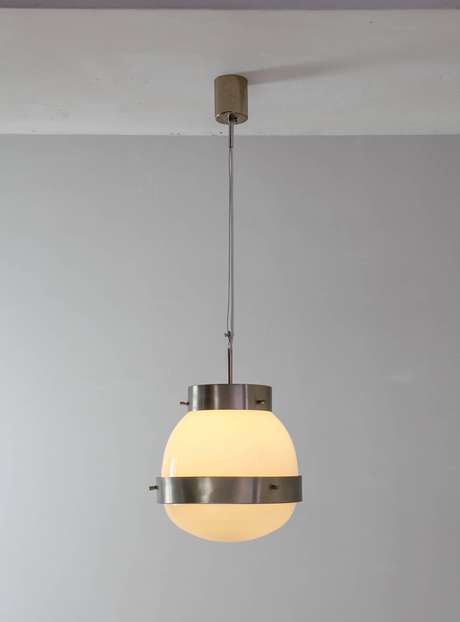 A height-adjustable 'Delta' pendant designed by Sergio Mazza for Artemide, circa 1960.
The lamp is made of brushed, nickel-plated brass with a two-part glass diffuser. The upper part is made of opaline glass and the lower part of pressed crystal.