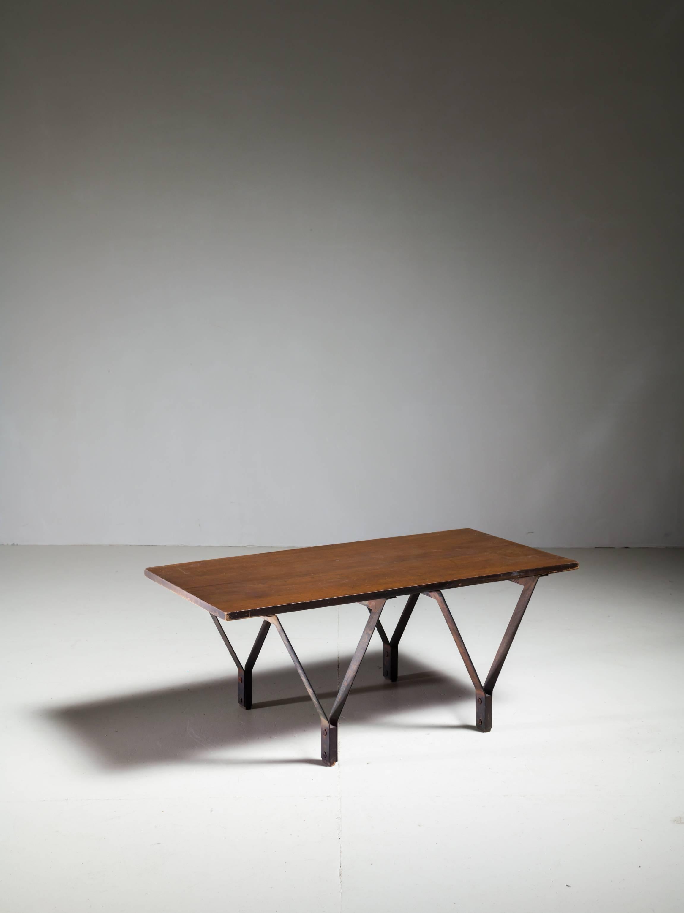 A rectangular, low coffee table made of a wooden top resting on four V-shaped metal legs. The legs have wooden feet, fixed between the metal.
* This piece is offered to you by Bloomberry, Amsterdam *

The legs show a strong resemblance to the work