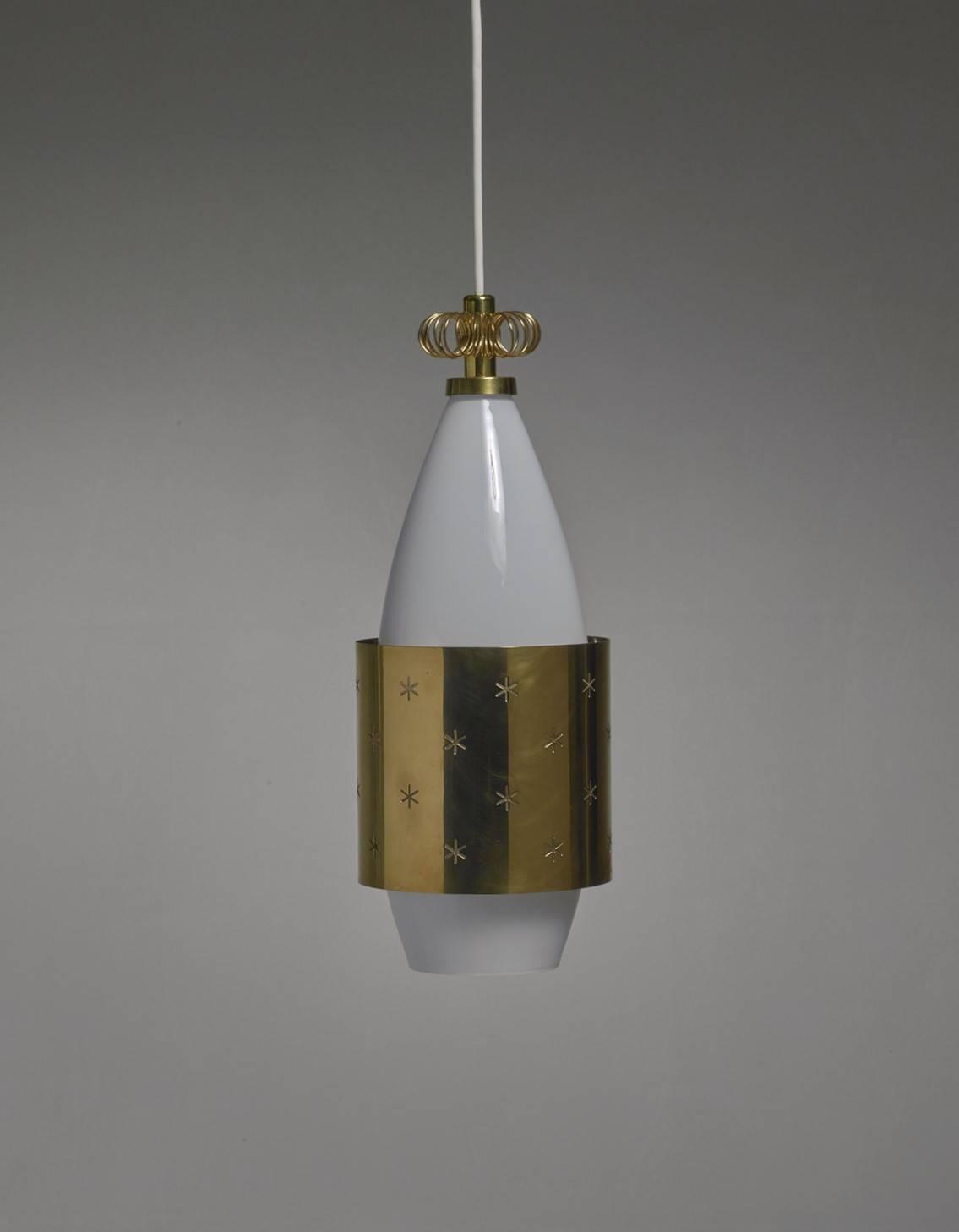 A rare model K2-12 pendant by Paavo Tynell for Idman. The lamp is made of an opaline glass diffuser and a brass shade and crown. The shade has star-shaped perforations.