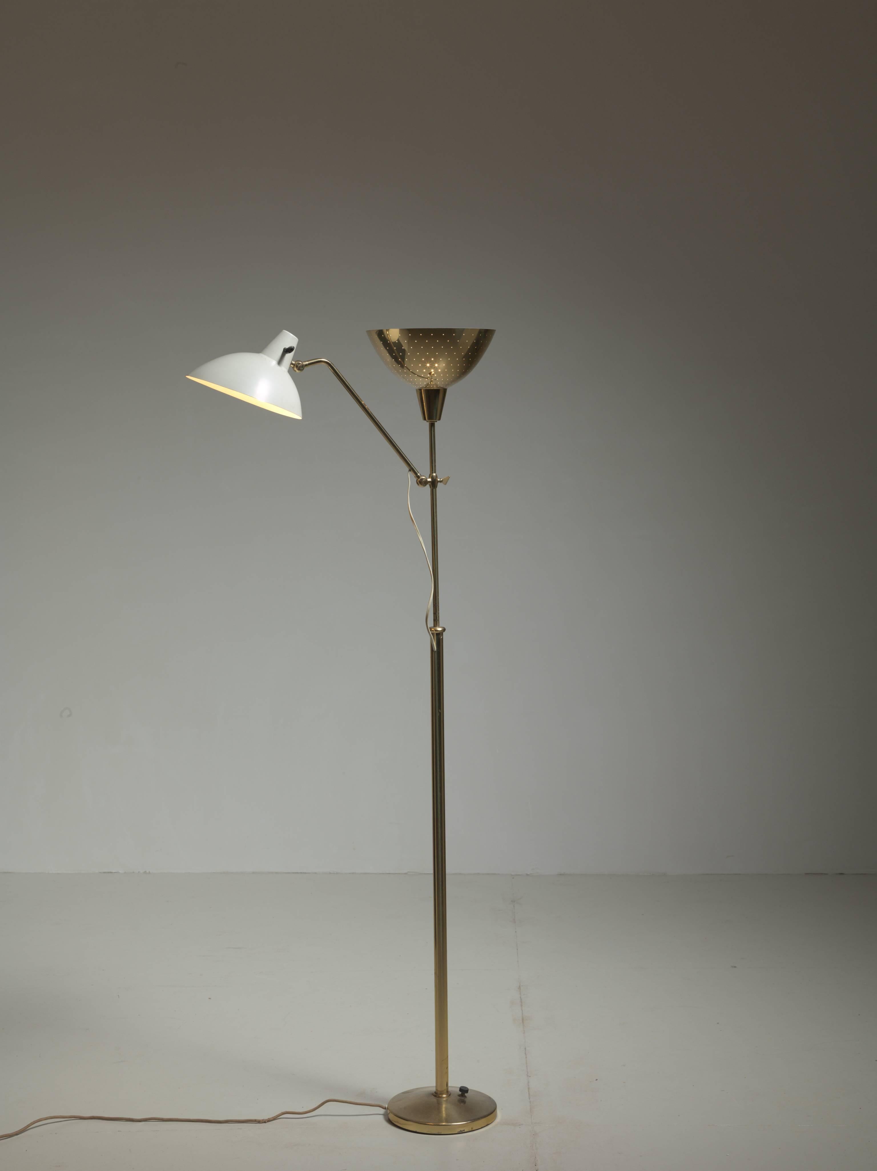 A stunning floor lamp with two shades, one brass uplighter and a height-adjustable shade of white lacquered metal. Designed by Alfred Muller for Swiss lighting company  AMBA. 
The brass shade has pin point perforations for a beautiful light