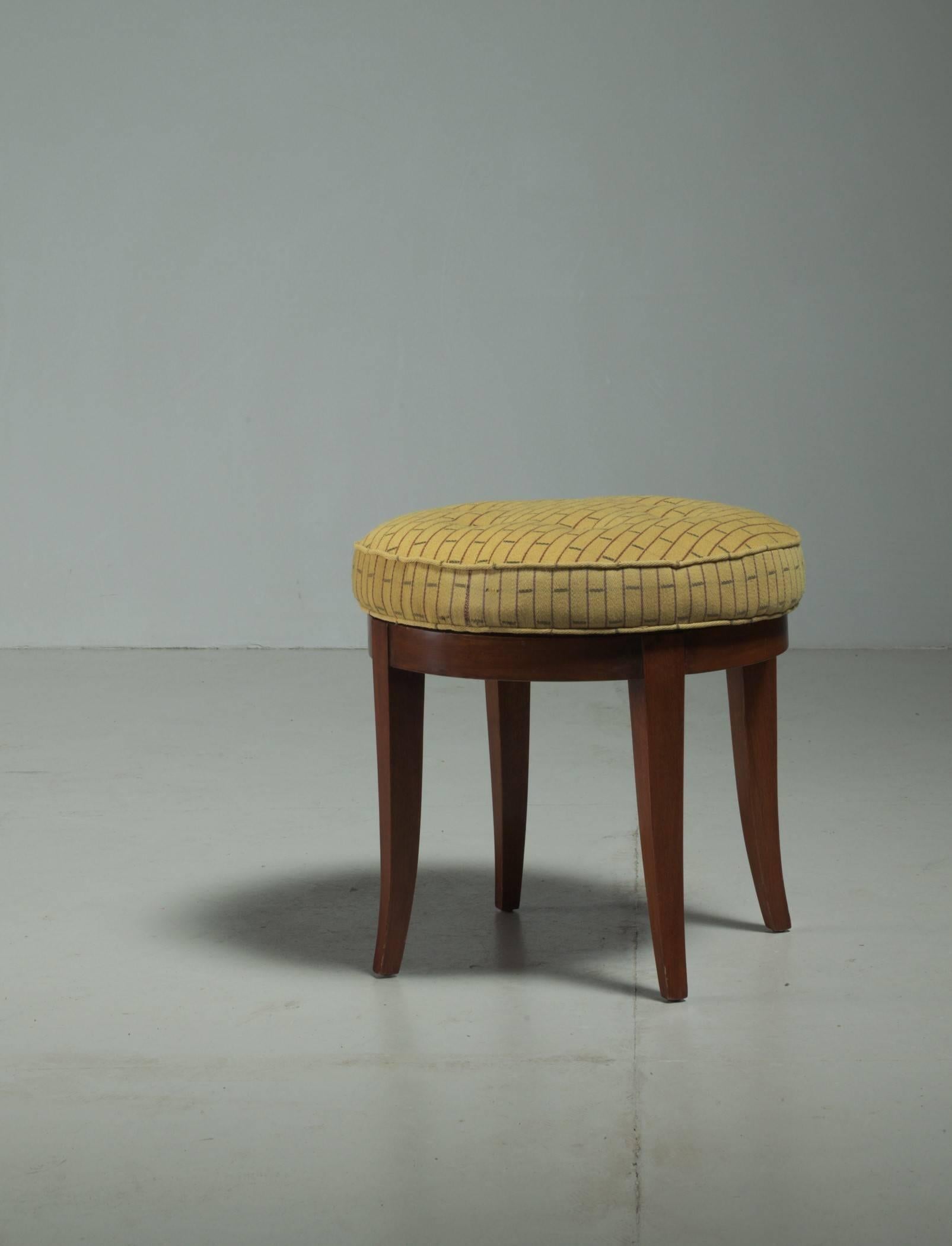 A rare oak, custom-made Paul Frankl swivel stool from a Los Angeles Interior by Frankl, which was documented in a House Beautiful magazine in 1945. The stool has been refinished and reupholstered with a yellow patterned fabric and the filling has