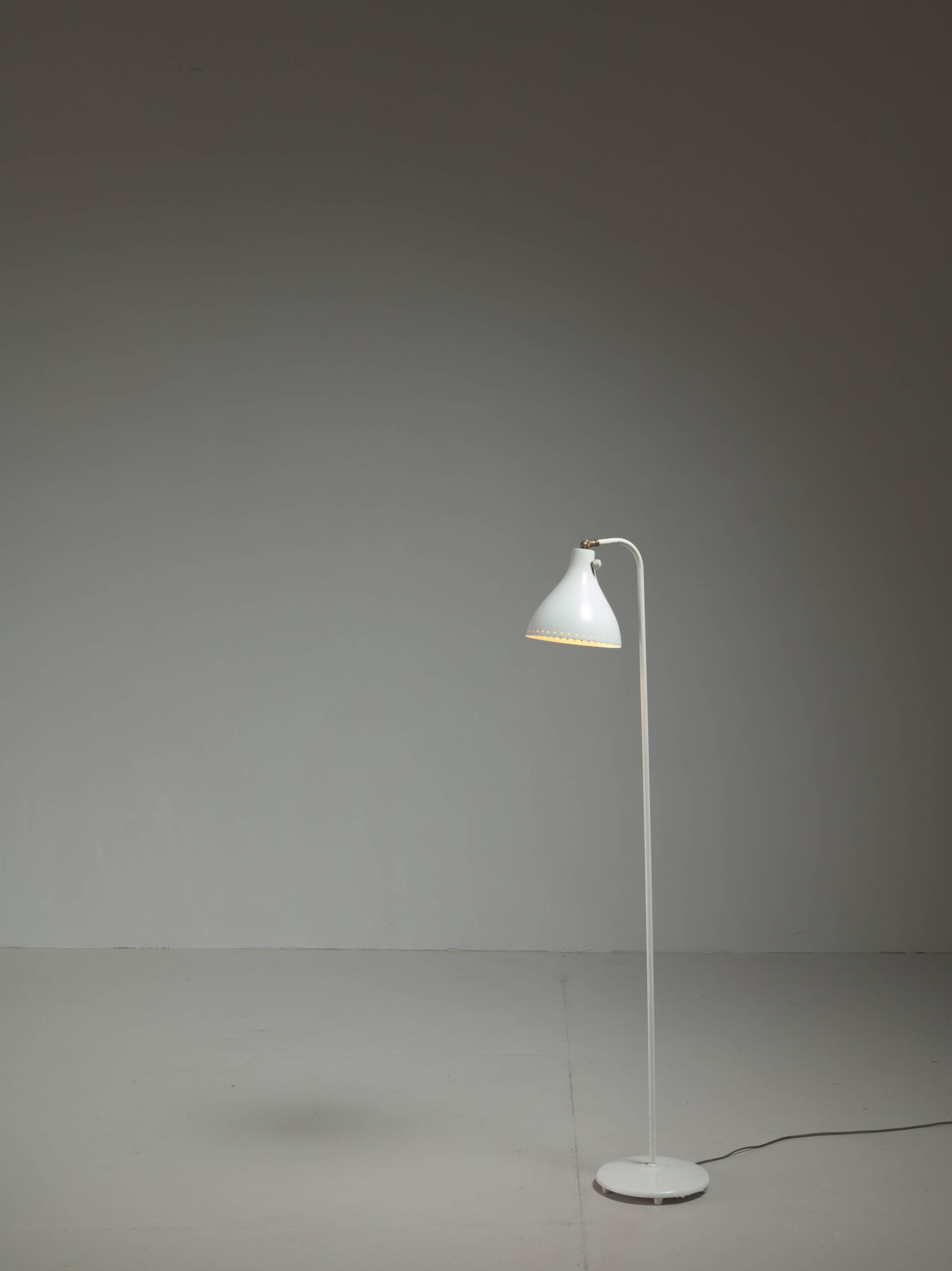 A white floor lamp by Norwegian designer Jac Jacobsen. The shade is adjustable due to the ball joint connection, which makes it a great reading lamp.
There are nice details, such as the structured holes in the hood, the switch on the hood, end the