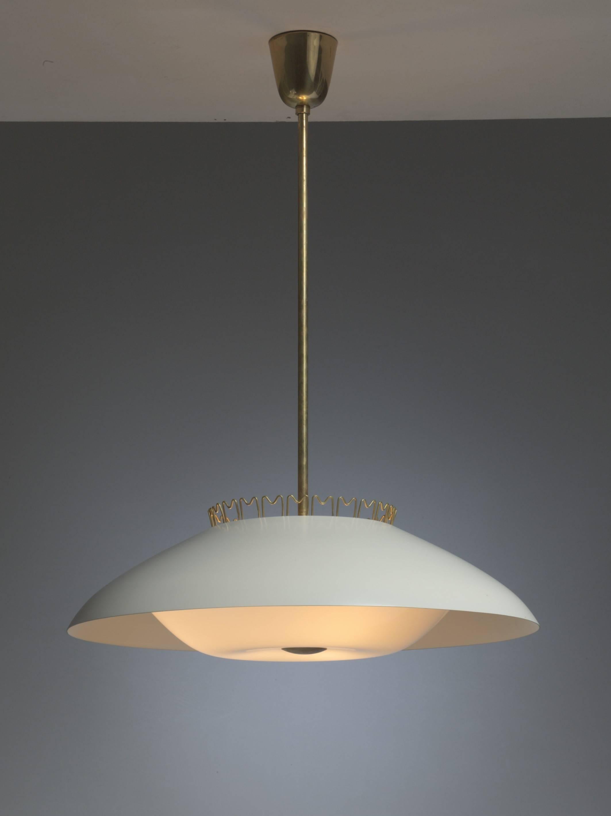 A rare model 1118 pendant lamp from the early 1950s by Lisa Johansson-Pape for Stockmann-Orno. This large (60 cm diameter) pendant is made of a cream lacquered metal shade, an opaline diffuser and a brass stem. The lamp is crowned with brass