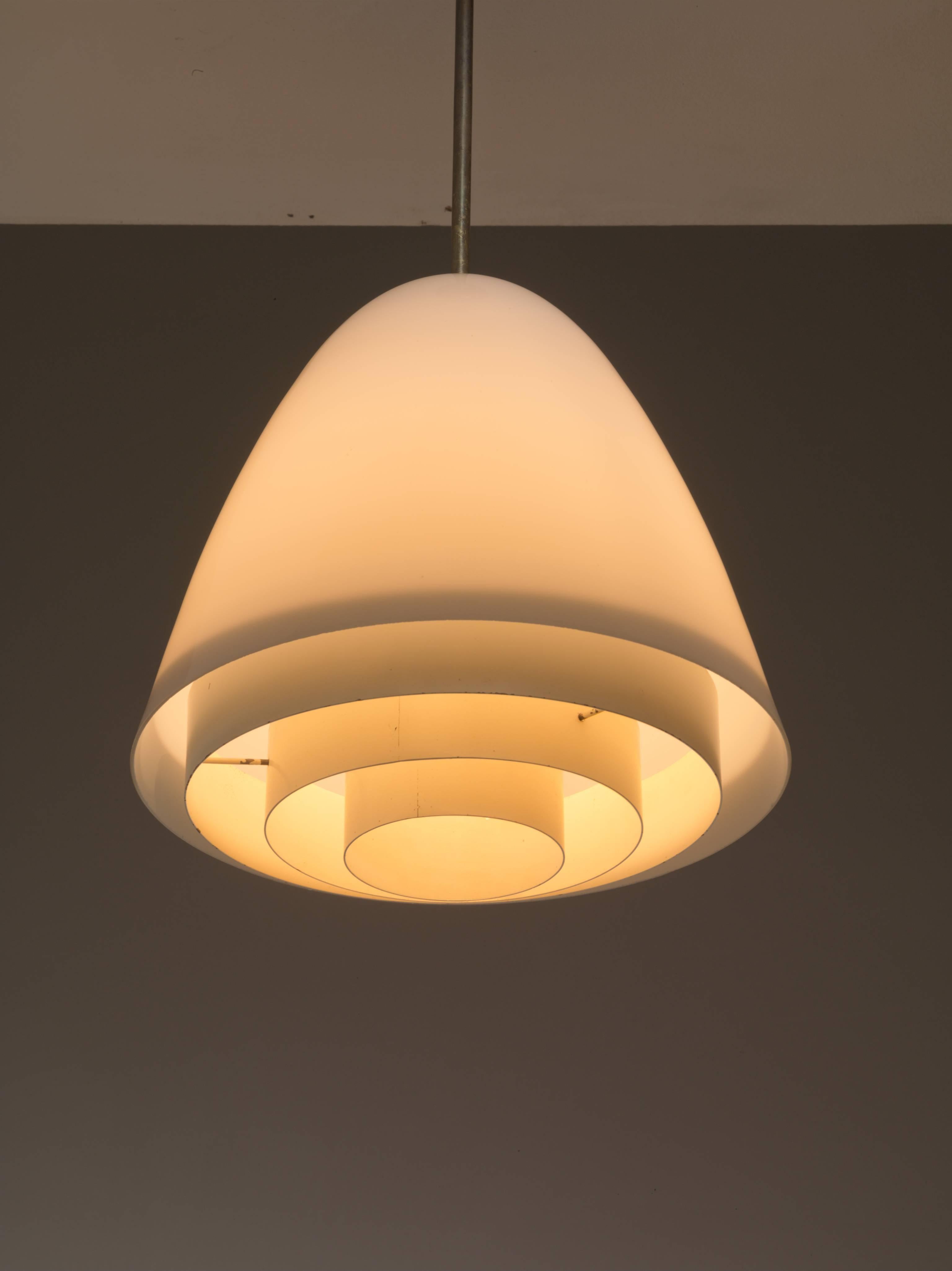 A rare finish pendant made of a bell shaped opaline glass shade with a white lacquered metal grid underneath. The lamp is connected to the ceiling with a brass stem.
A stunning, minimalistic design and the lamp is in a great, original condition.
 