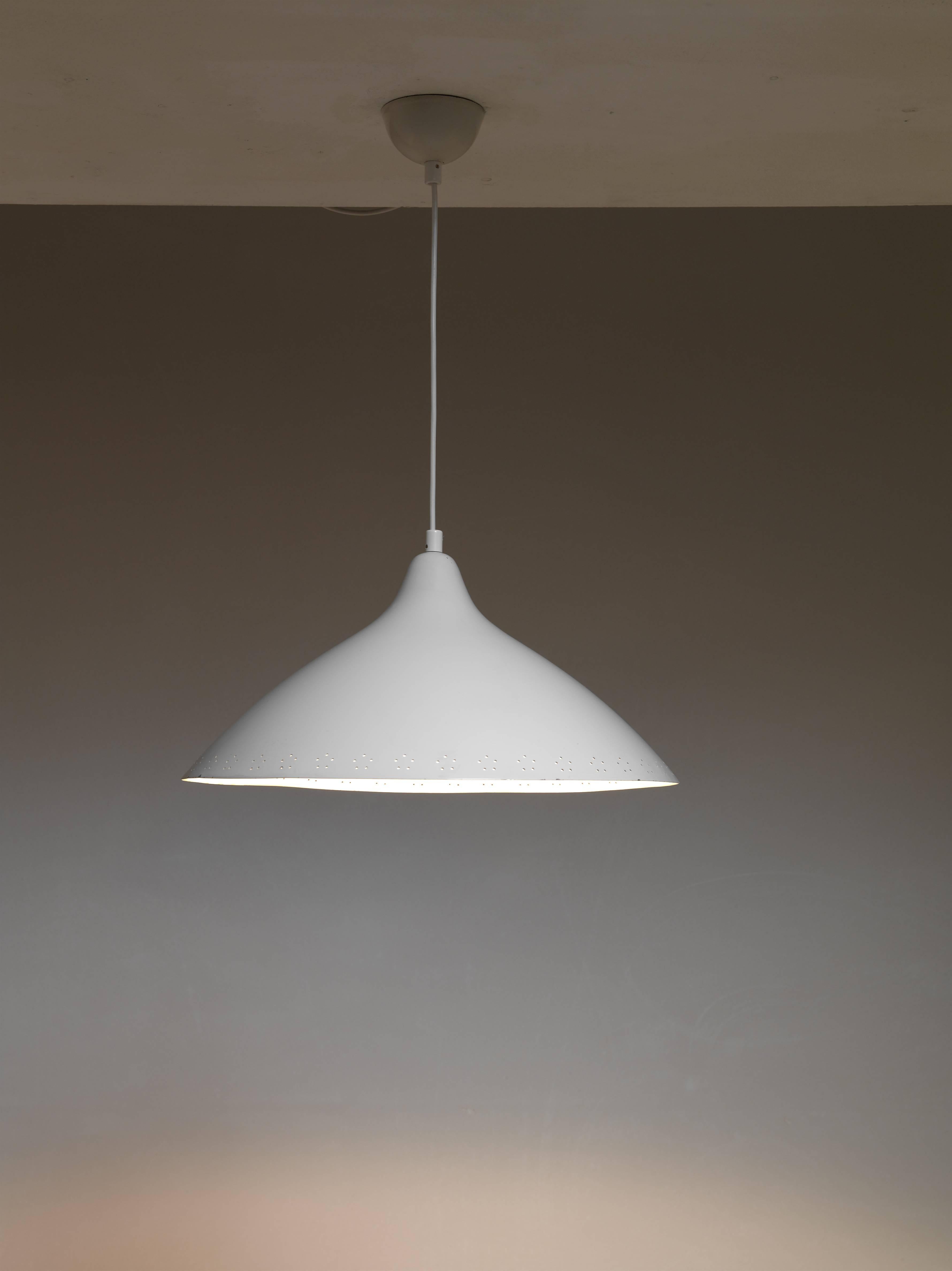 A rare version of the model 1100 pendant lamp by Lisa Johansson-Pape for Orno, Finland. The shade is made of white lacquered metal. The pin point perforations around the edge are a beautiful detail.