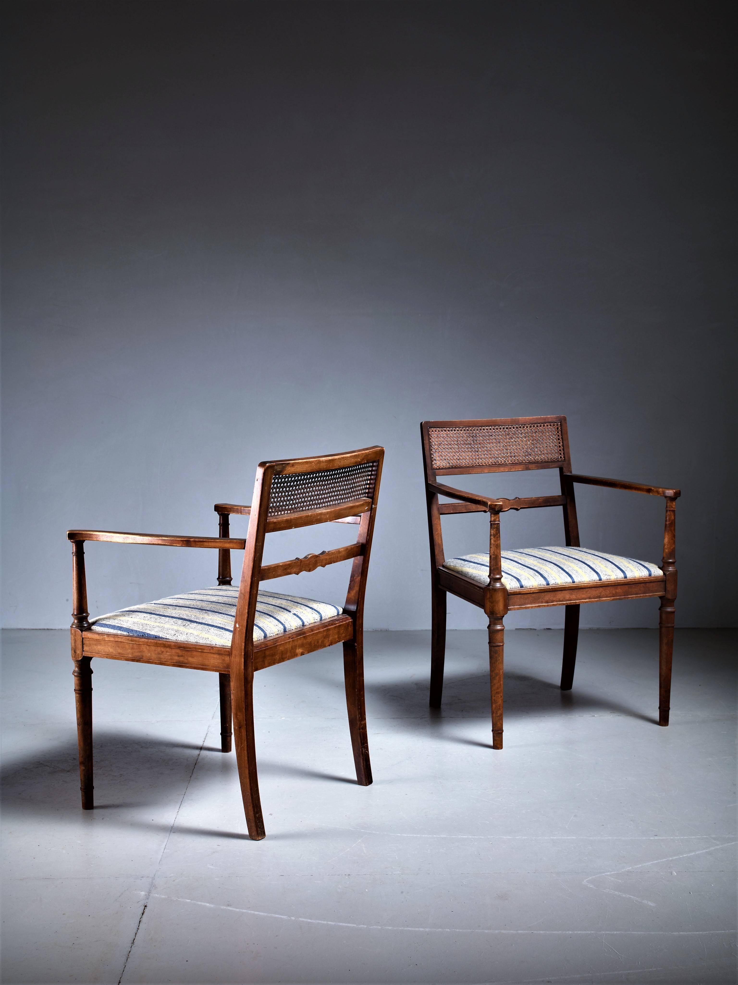 A pair of armchairs designed by Axel Einar Hjorth for Svenska Möbelfabriken, Bodafors. The chairs are made of stained birch with a woven rattan backrest. The seating has a striped fabric upholstery.
Marked 'SMF'.
Wonderful set of chairs that fits