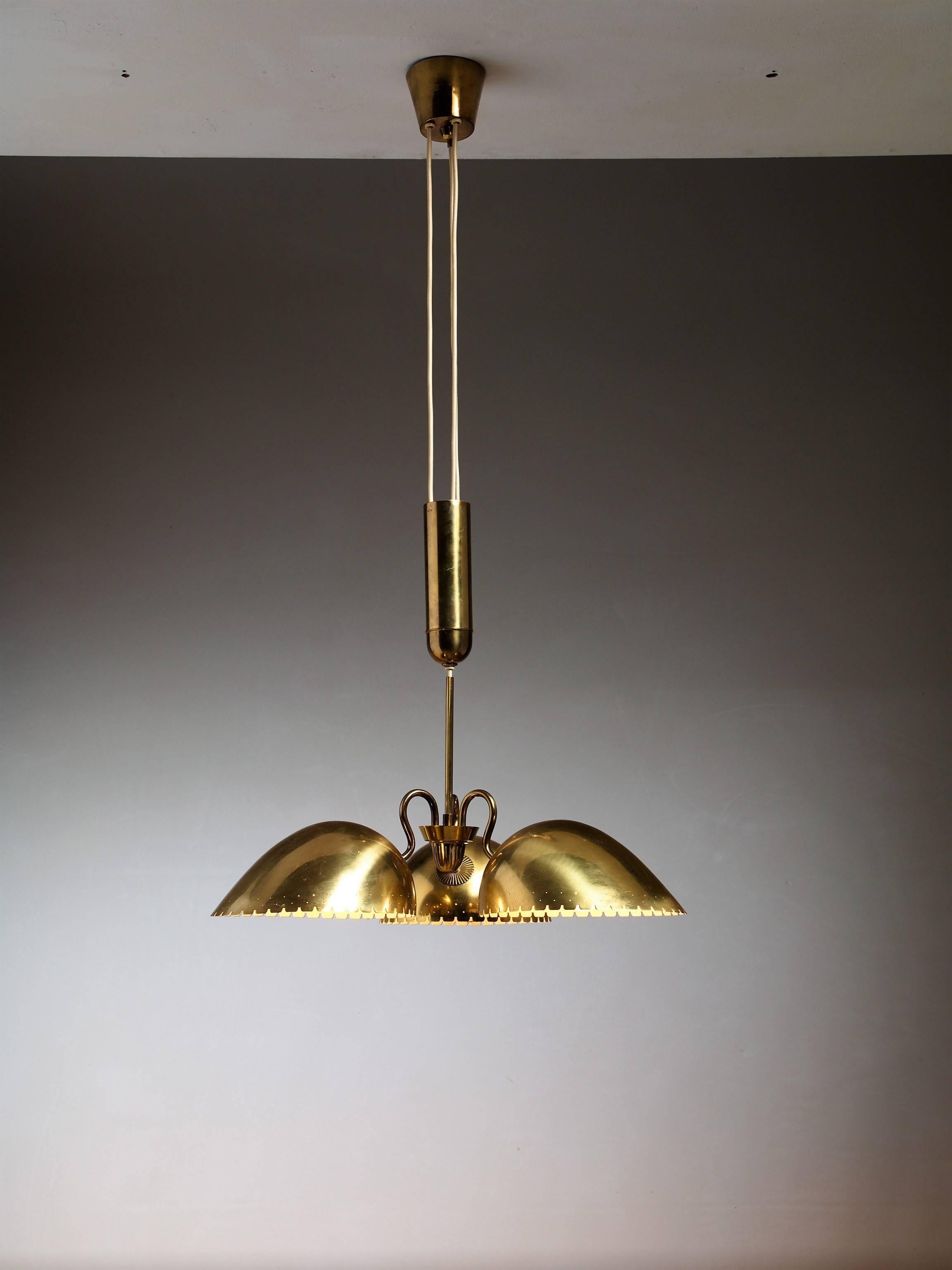 A wonderful brass pendant with a counterweight in the center from Sweden by Bertil Brisborg for Bohlmarks. The lamp has three shades with serrated and perforated edges, facing downwards.

The height mentioned is the height of the shade itself,
