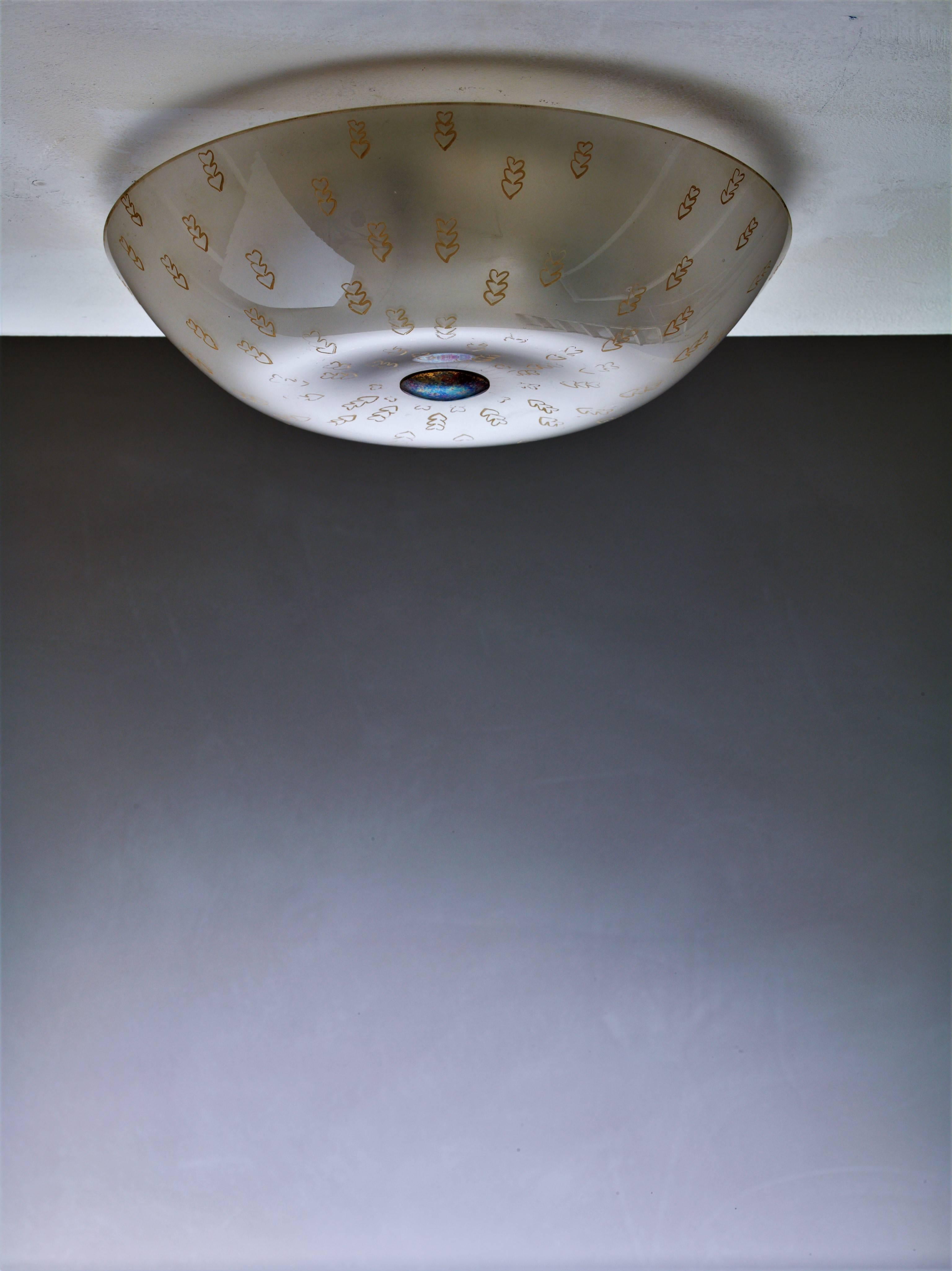 A model '1001' flush mount by Lisa Johansson-Pape for Orno. The curved diffuser is made of frosted glass with painted decorations.
The lamp has three light bulbs and is marked by Orno. A beautiful neoclassical flush mount.