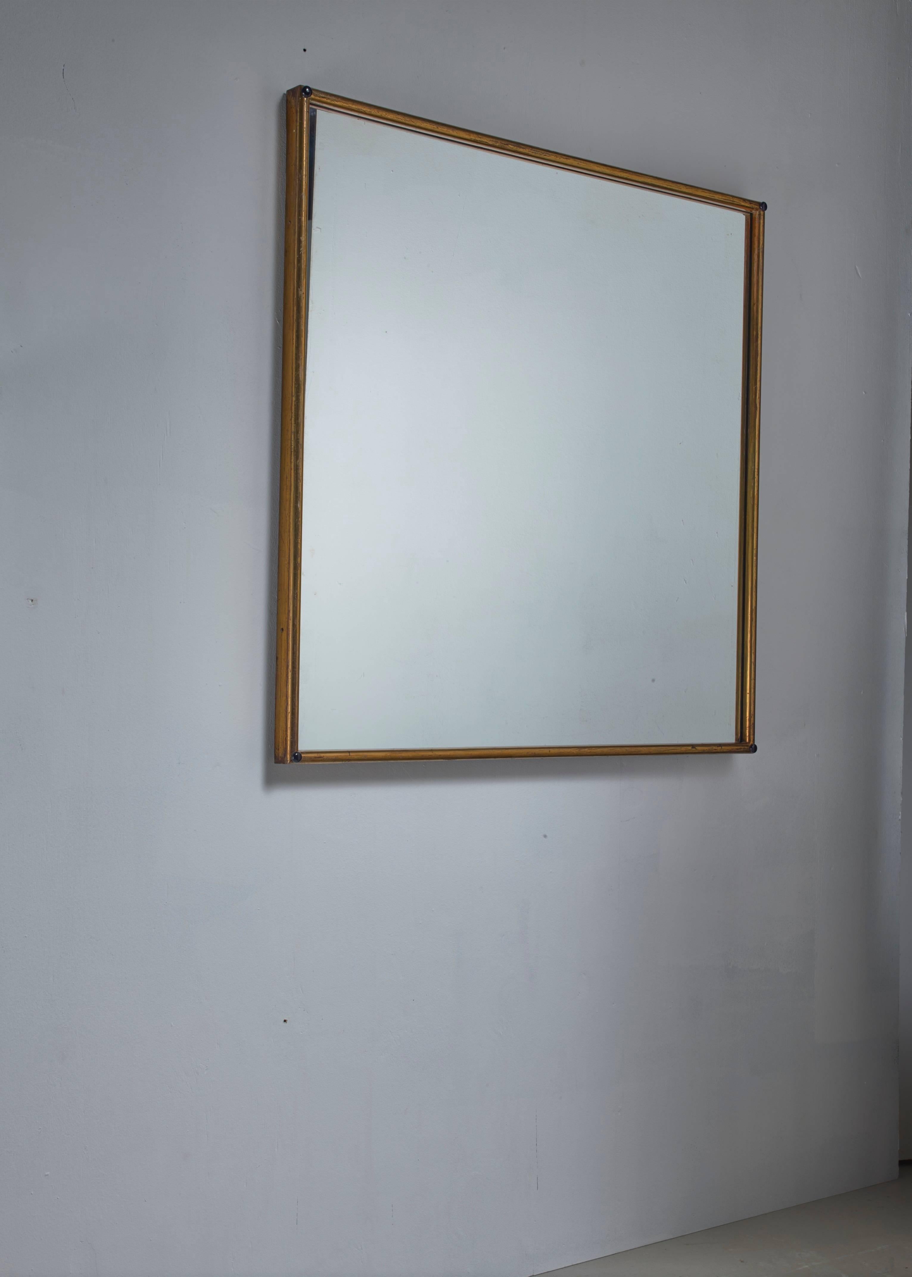 A large Italian wall mirror in a square brass frame.