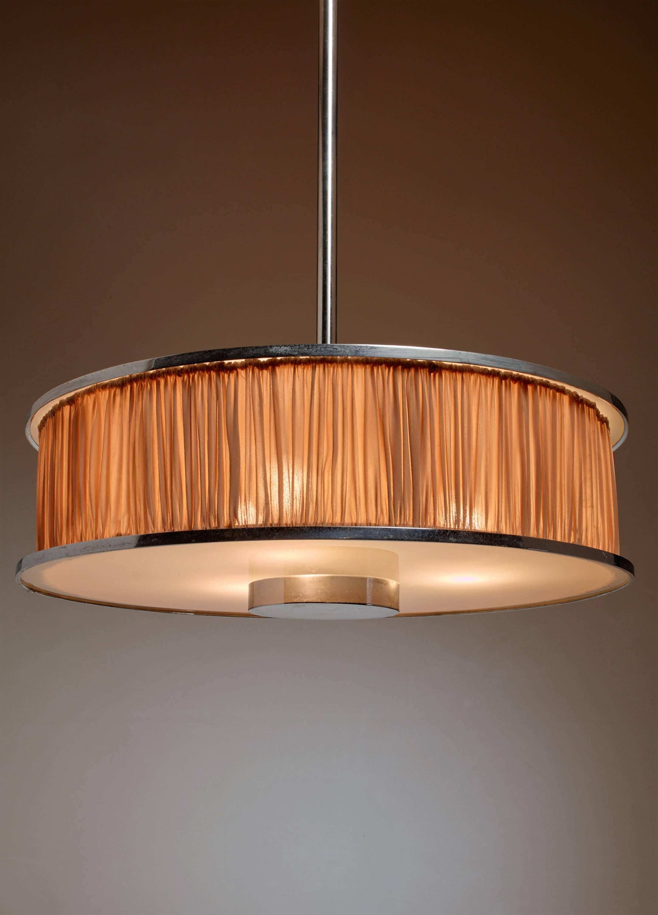A large Italian modernist pendant lamp from the early 1920s. The lamp is made of two round nickel plated frames with a frosted glass diffuser and a silk shade between them. It hangs from a nickel-plated stem.
