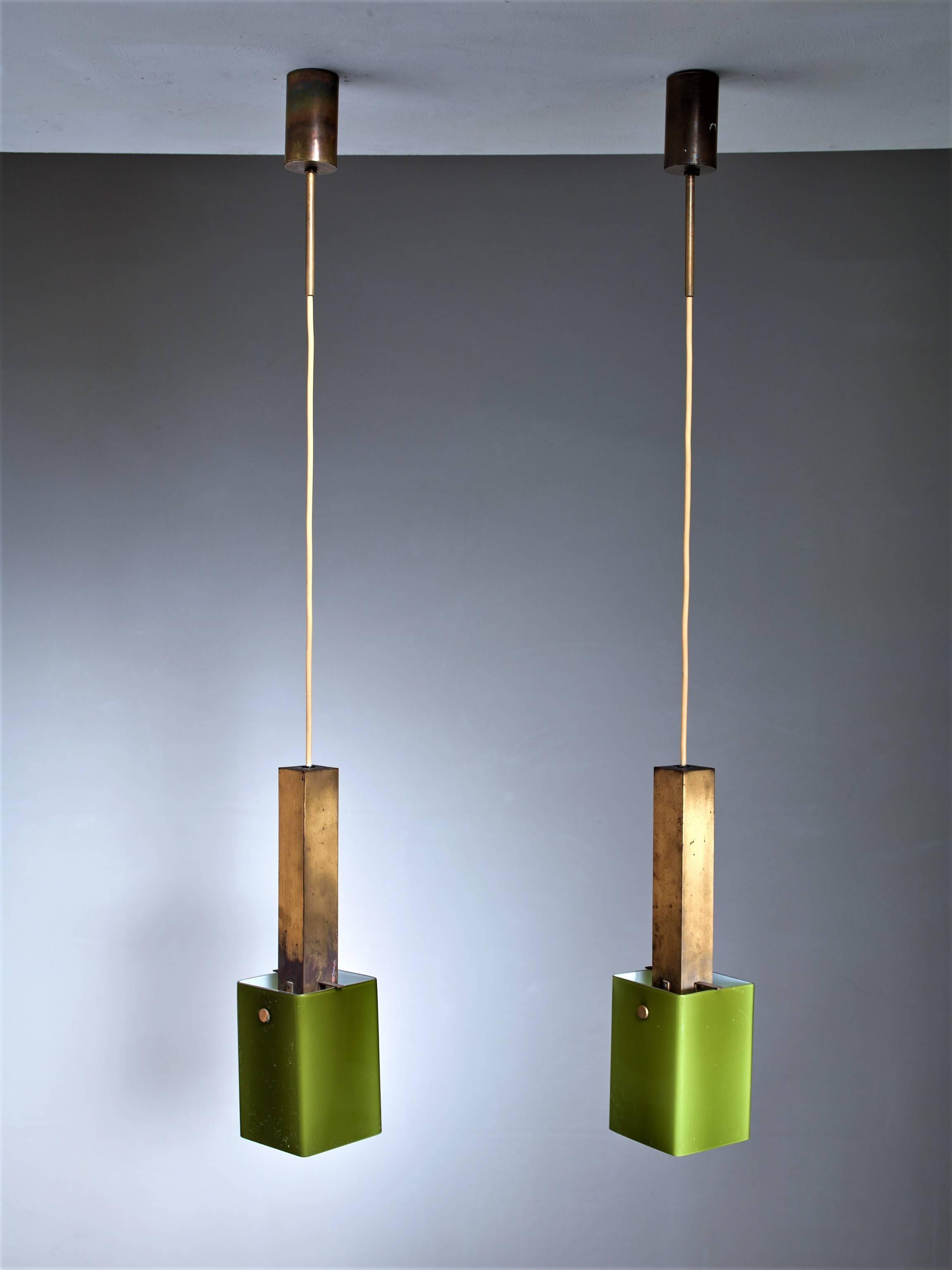 A pair of Italian pendants, made of a rectangular brass stem with a green glass shade hanging from it. The style is reminiscent of Vistosi.
The glass shades are 12 by 12 cm and are 18 cm high.

* This set is curated for you by Bloomberry, Amsterdam *