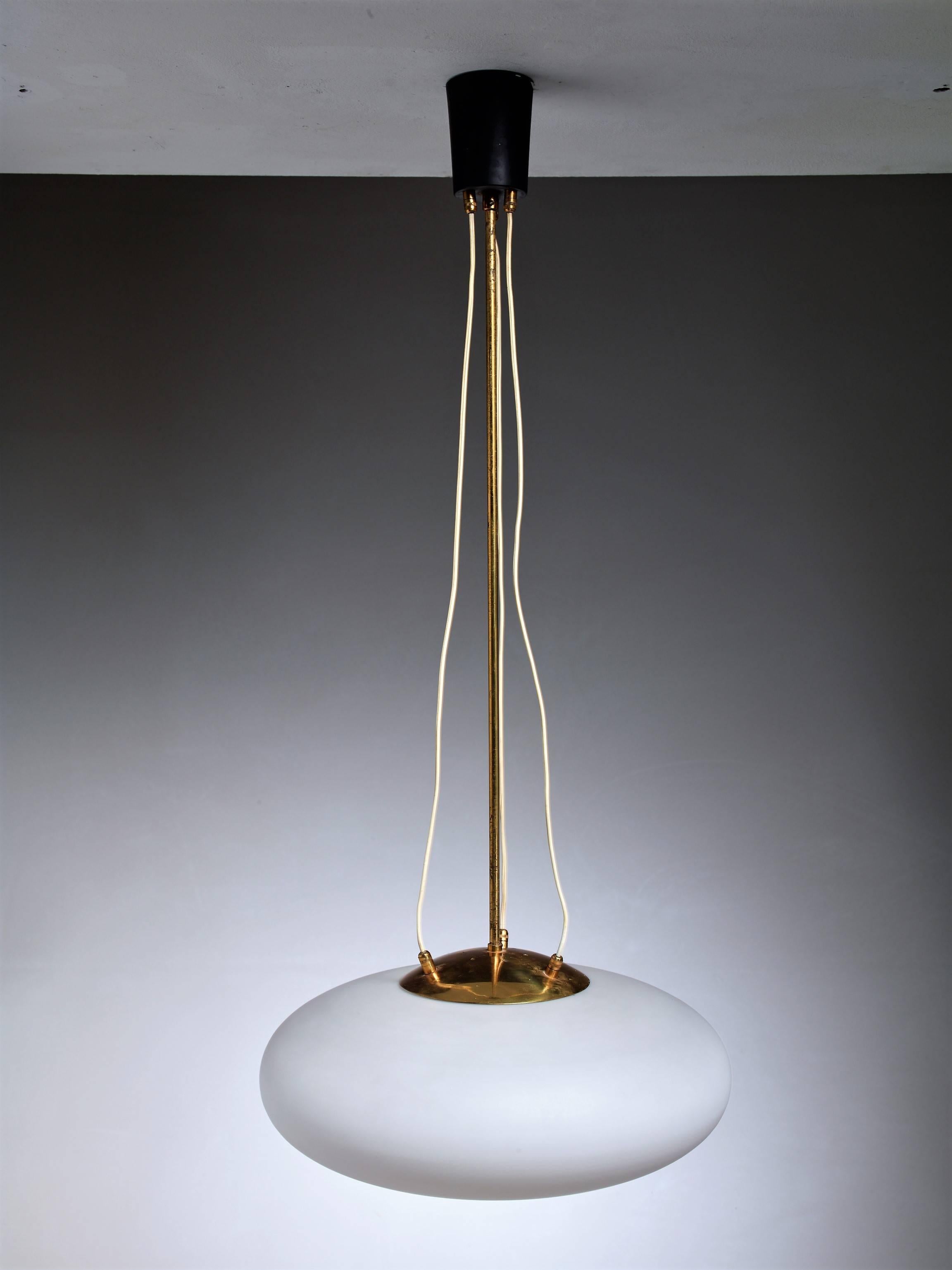 An Italian pill-shaped opaline glass pendant lamp hanging from a brass stem.