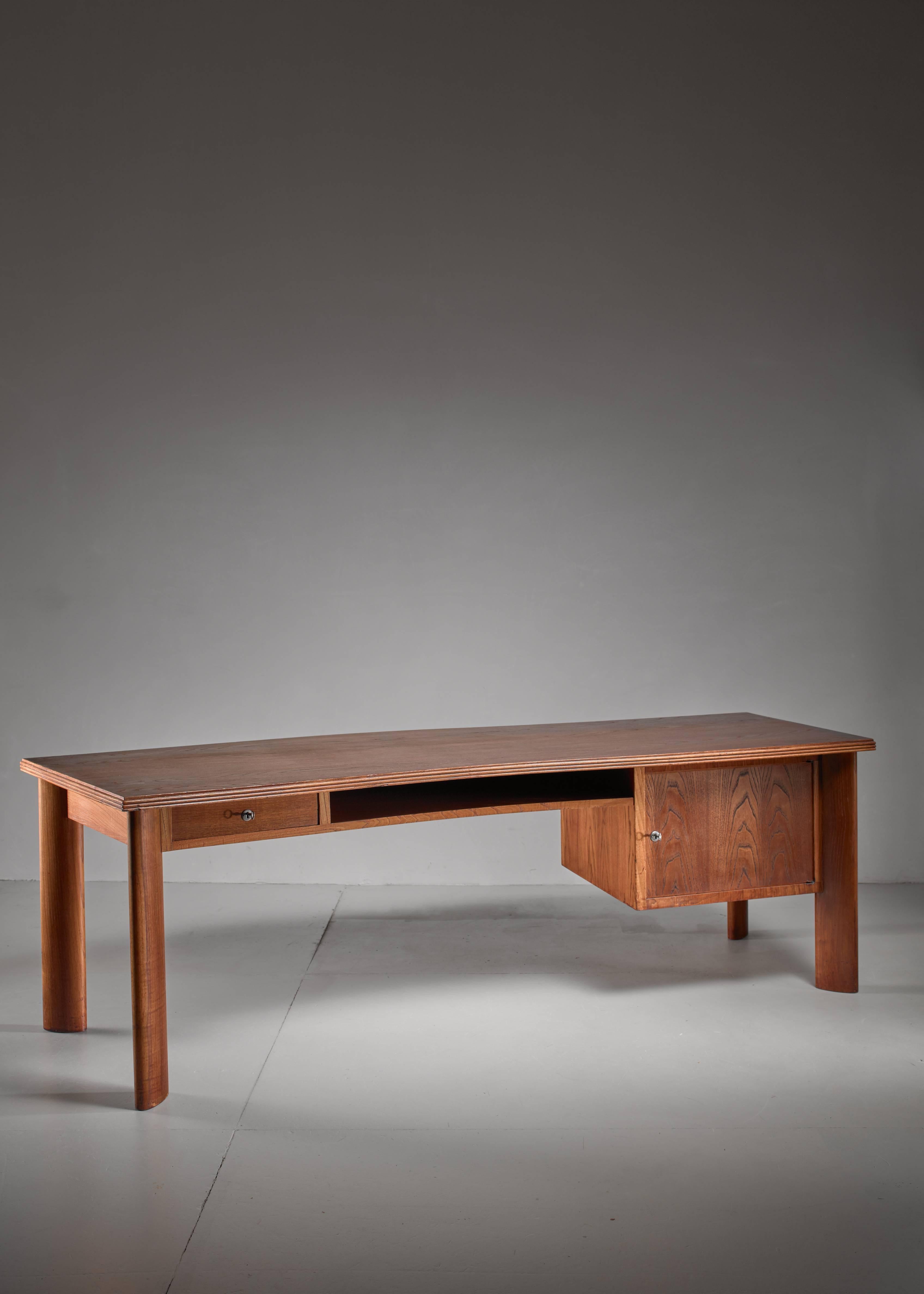 A large teak desk by Bela Angelus. The Hungarian born but Milan based architect who worked between the 1930s and 1960s. The desk has a small drawer and storage space on the left and a larger storage with drawer on the right.
     