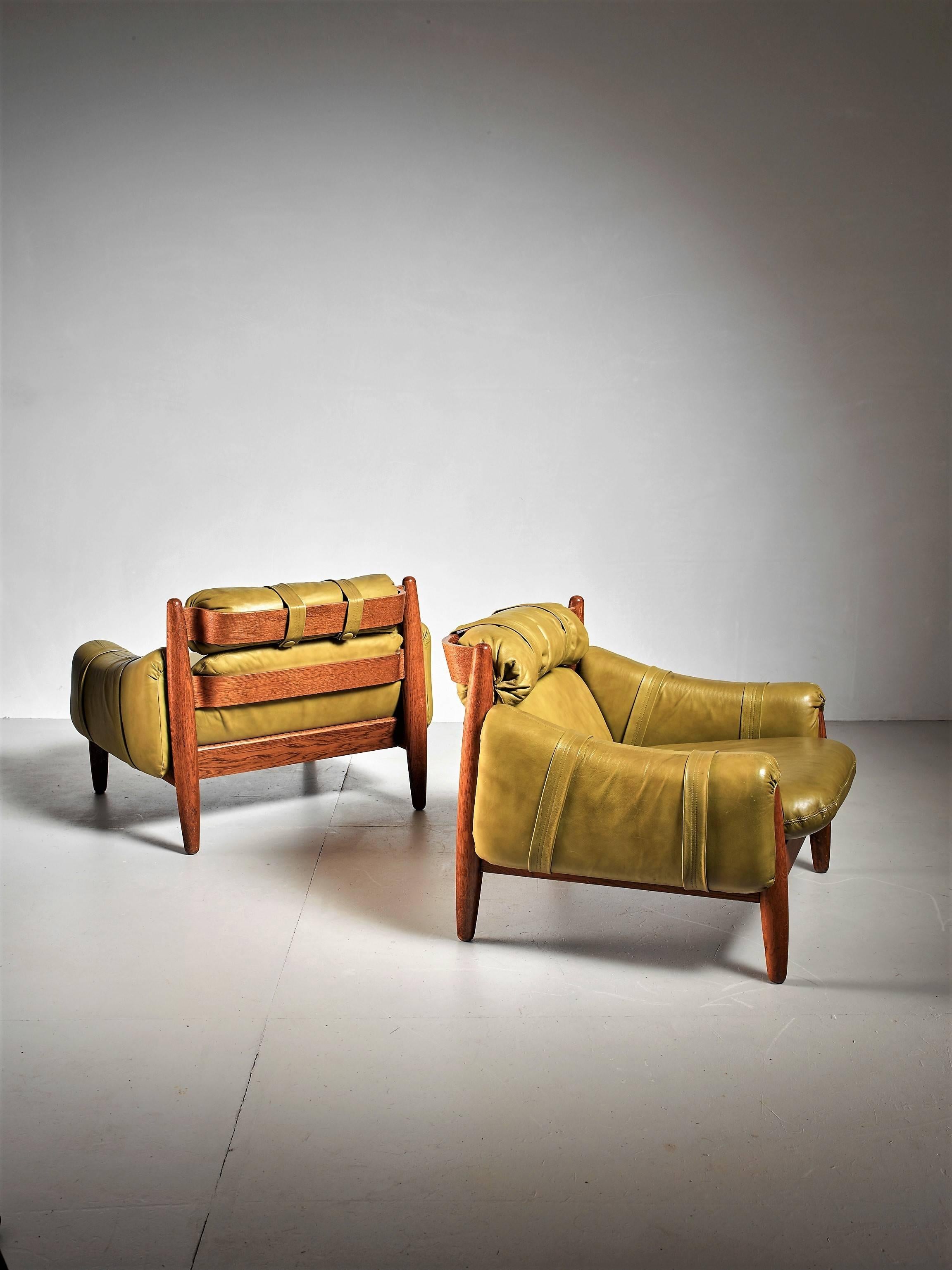 A pair of Brazilian lounge chairs in the manner of Percival Lafer. They are made of oak with green leather cushions.
