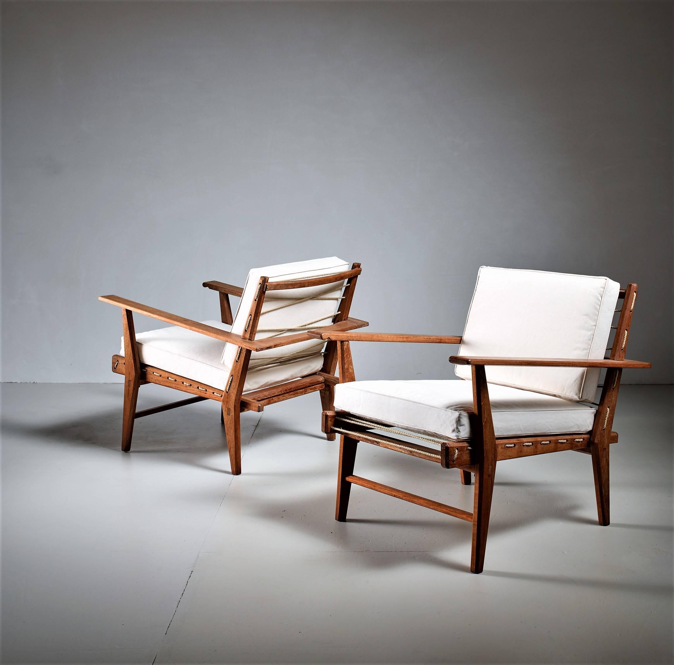 A gorgeous pair of rope chairs, along the lines of Franco Albini or Paolo Tilche. The chairs have off-white canvas cushions, resting on hemp rope.
They are beautifully made and the rope connection at the sides gives an elegant touch. The cushions