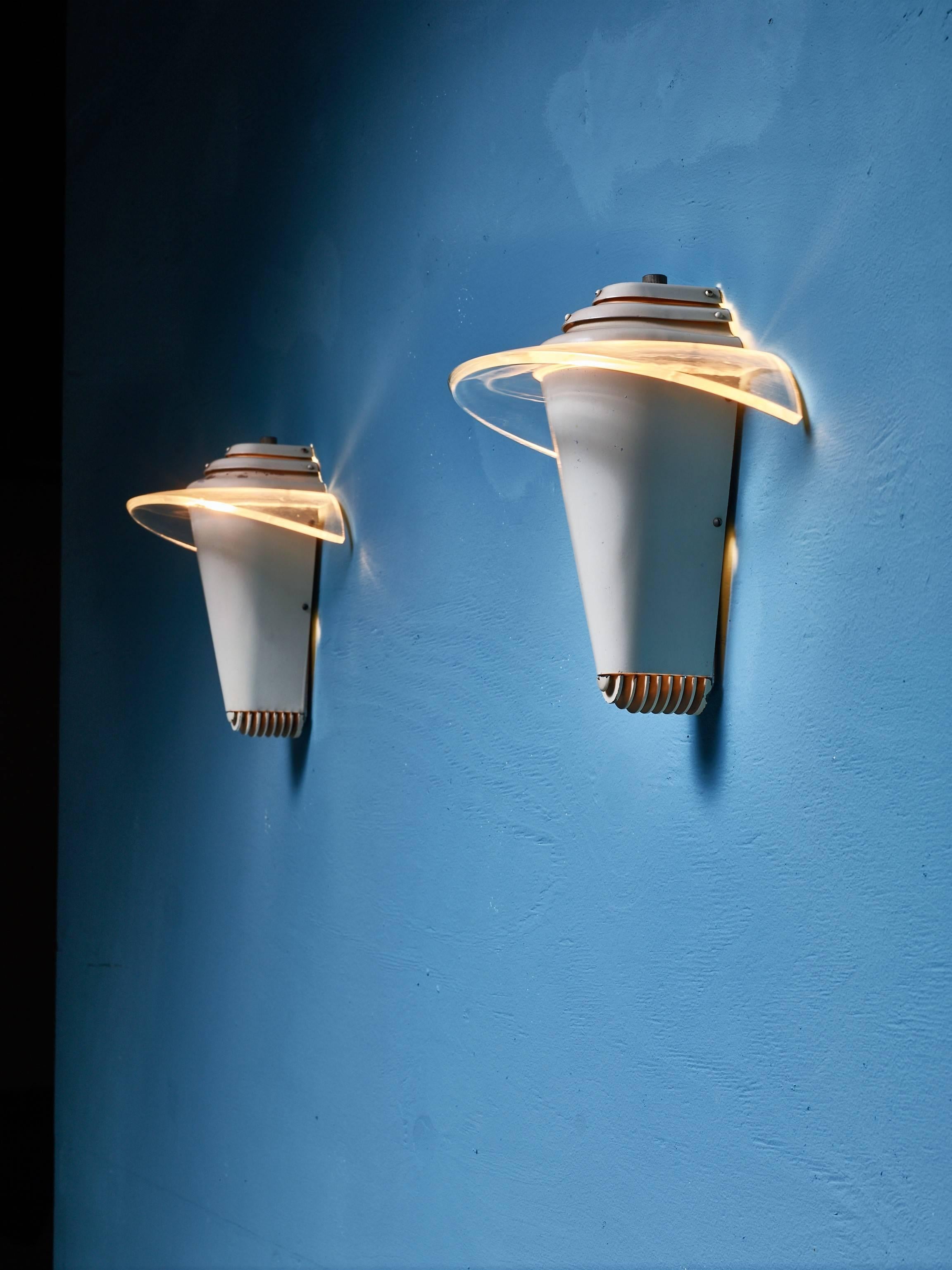 A pair of modernist wall lamps by English company Eralite MFG. The lamps are made of cream lacquered metal with curved plexiglass diffusers.
Marked by Eralite.

