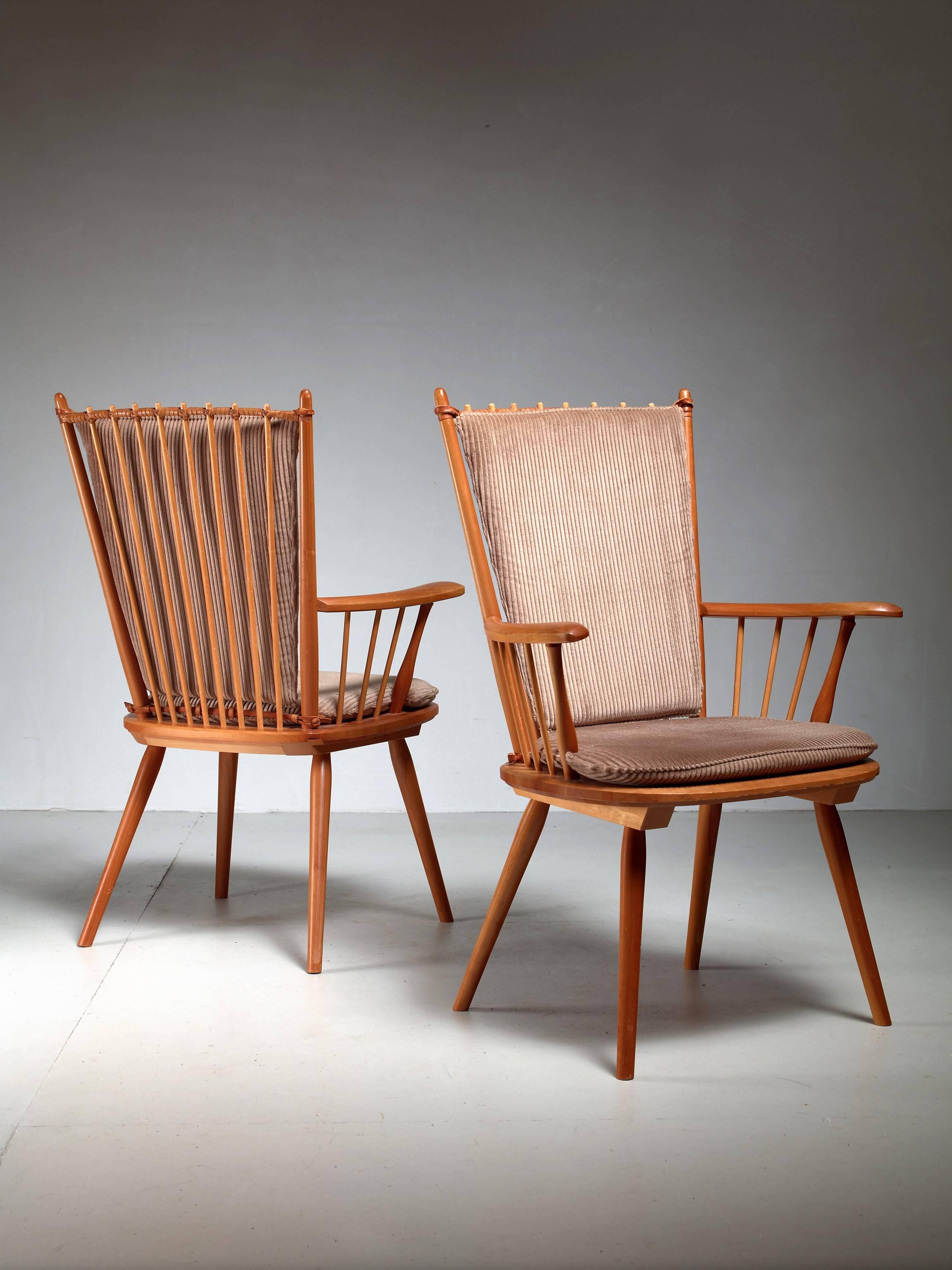 A pair of cherrywood arts and crafts chairs by Albert Haberer for Hermann Fleiner, Stuttgart, circa 1950.
The chairs have loose taupe fabric cushions. The flexible backrest is made of thin spindles, held together with a leather connection. The