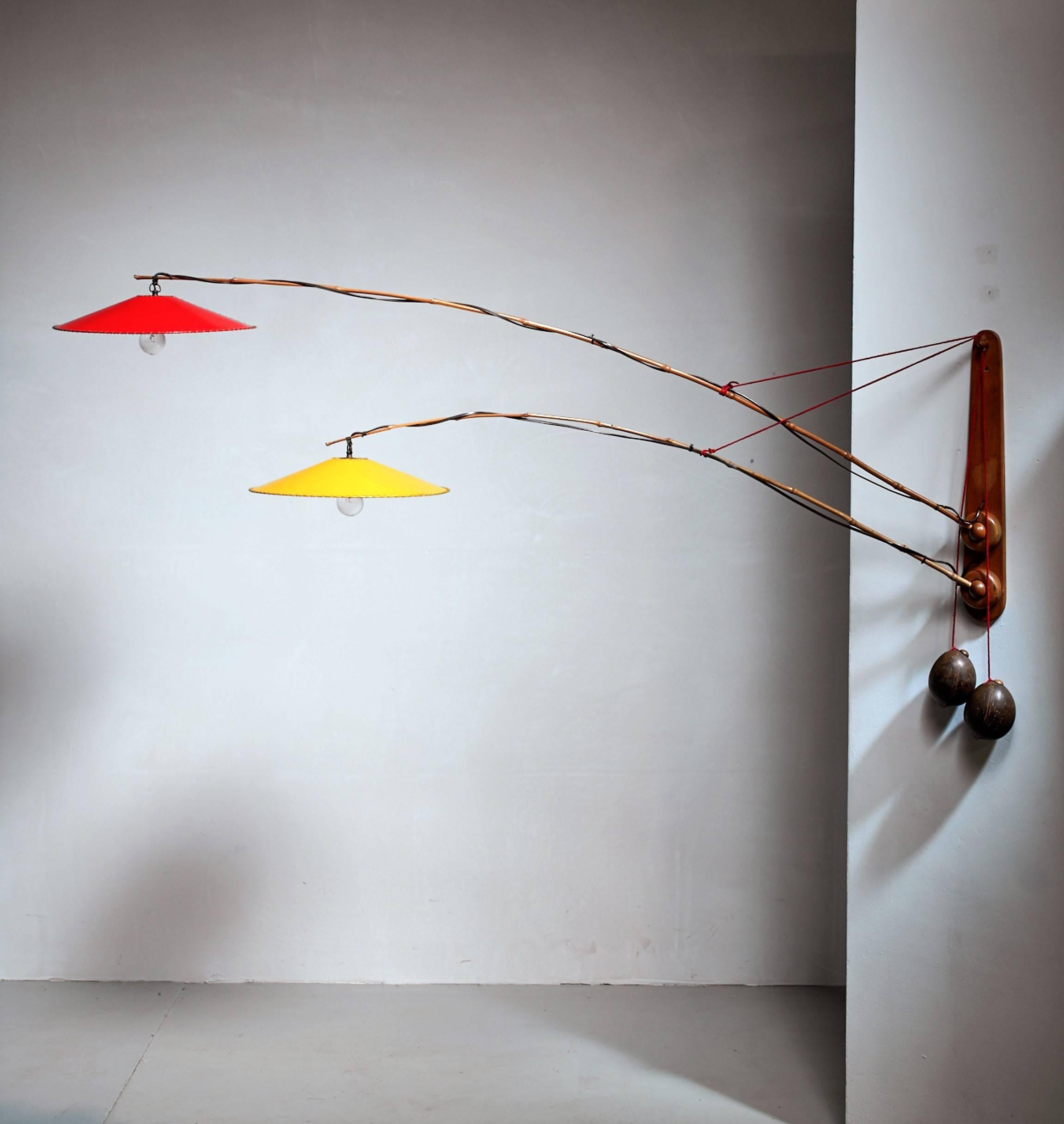 A wall lamp by Rupprecht Skrip, with two long bamboo arms and coconut counterweights. The arms extent from the wooden wall-mount with a ball-joint connection. The lamp has two plastic shades, one red and one yellow.





 