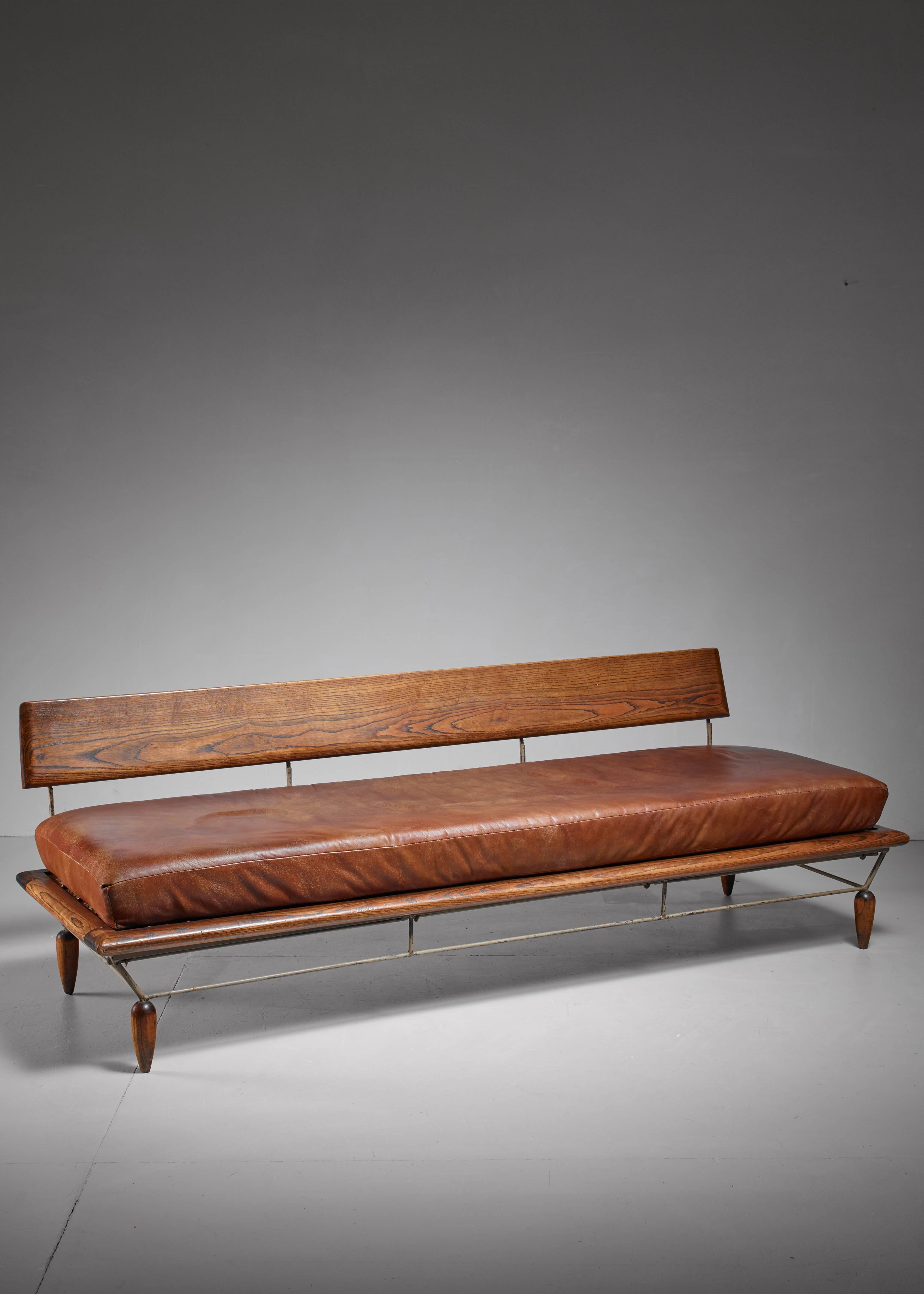 A unique sofa by Arizona designer Allen Ditson and his artist wife Lee Porzio. The chair is made of a metal and oak frame with loose brown leather cushions. The seating can be placed in two different positions; straight and slightly tilting.
* This