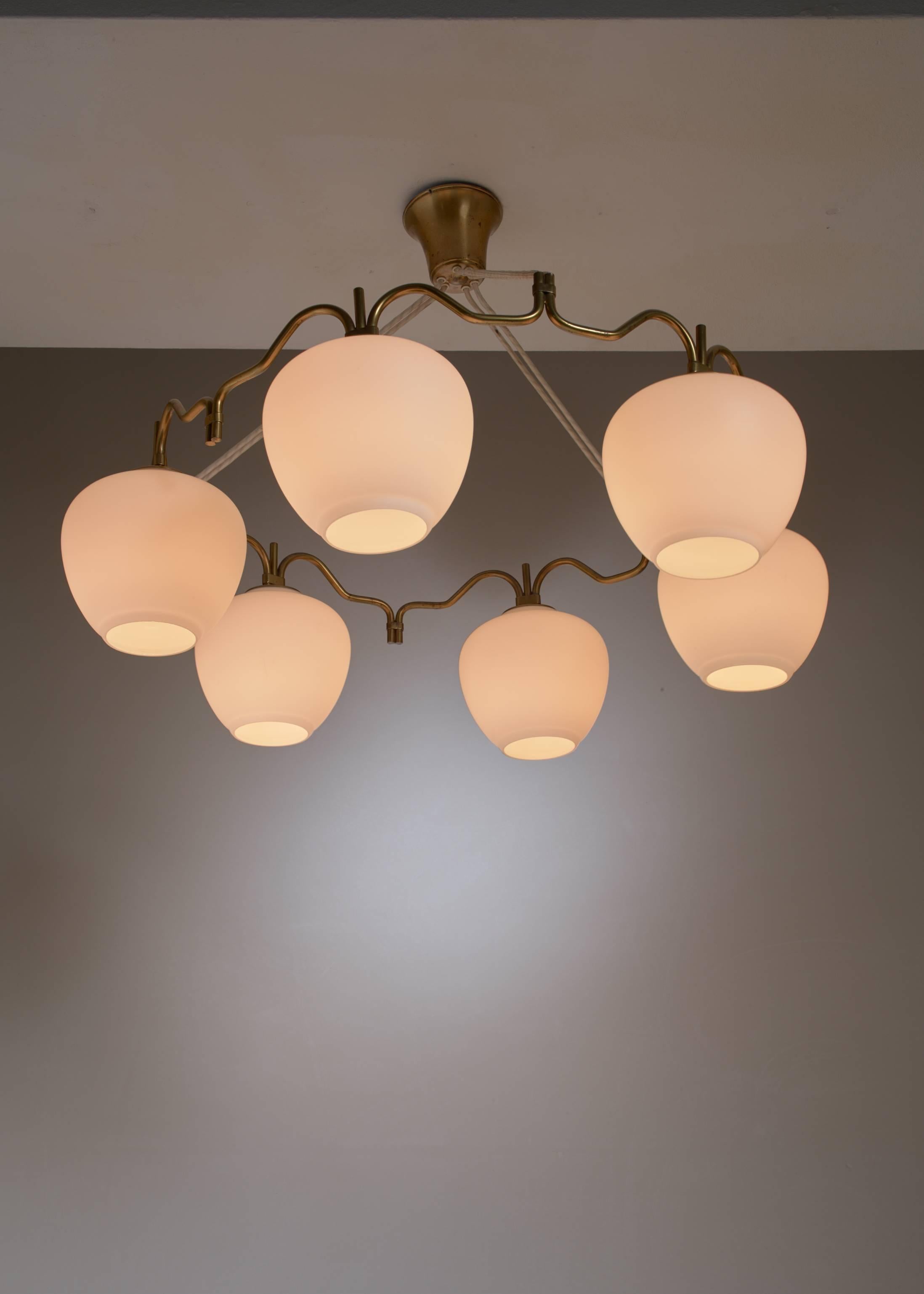 A round brass chandelier with six opaline glass shades, by Bent Karlby for Lyfa.

We have a second lamp of this model available.