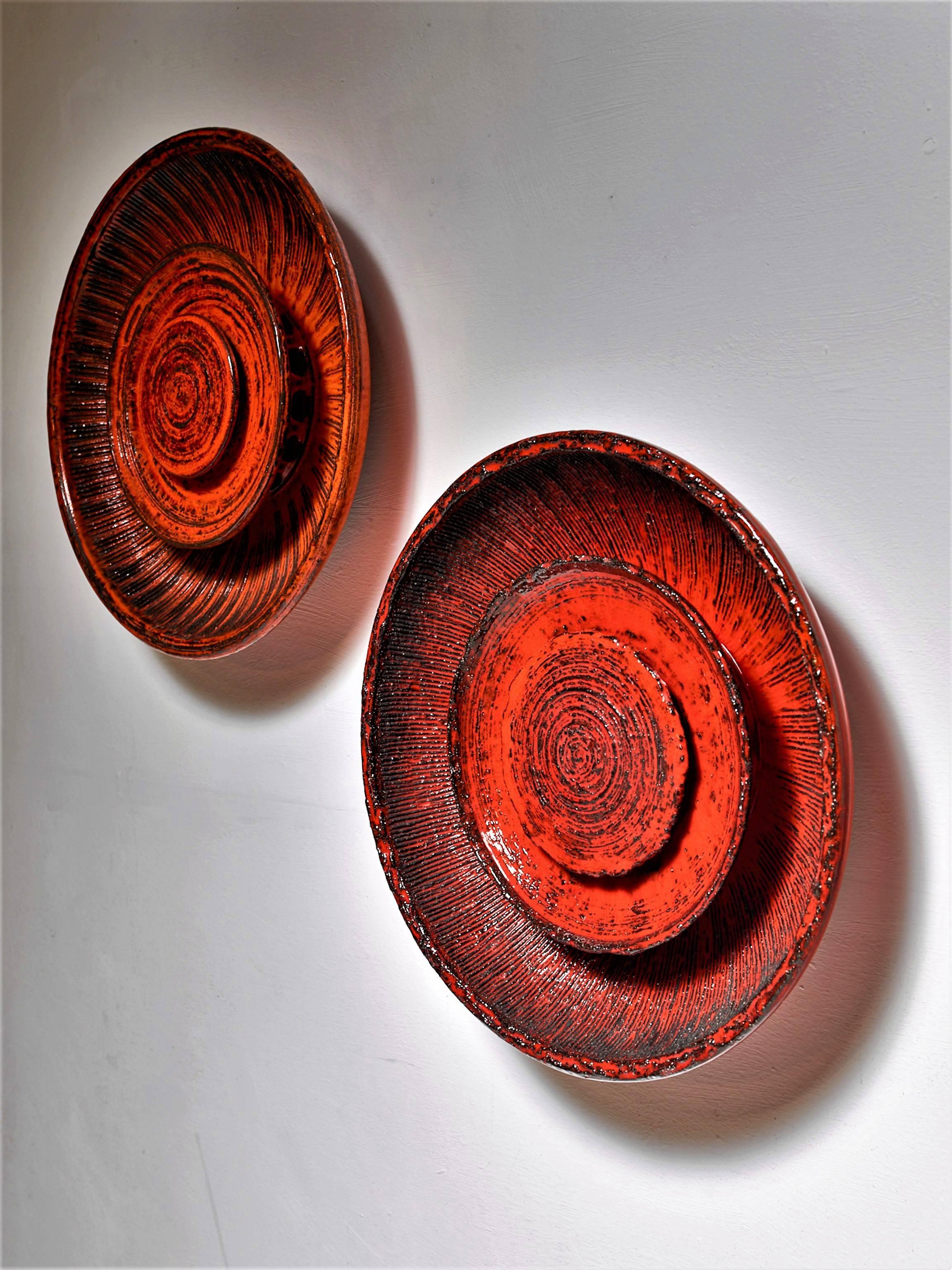 A pair of red ceramic wall lamps by Carl Johan Ege Nielsen for Dagnæs, Denmark. The lamp is made of a large bowl with two smaller discs inside. The light shines through round holes behind the discs, giving it a stunning light effect.
Marked by Ege