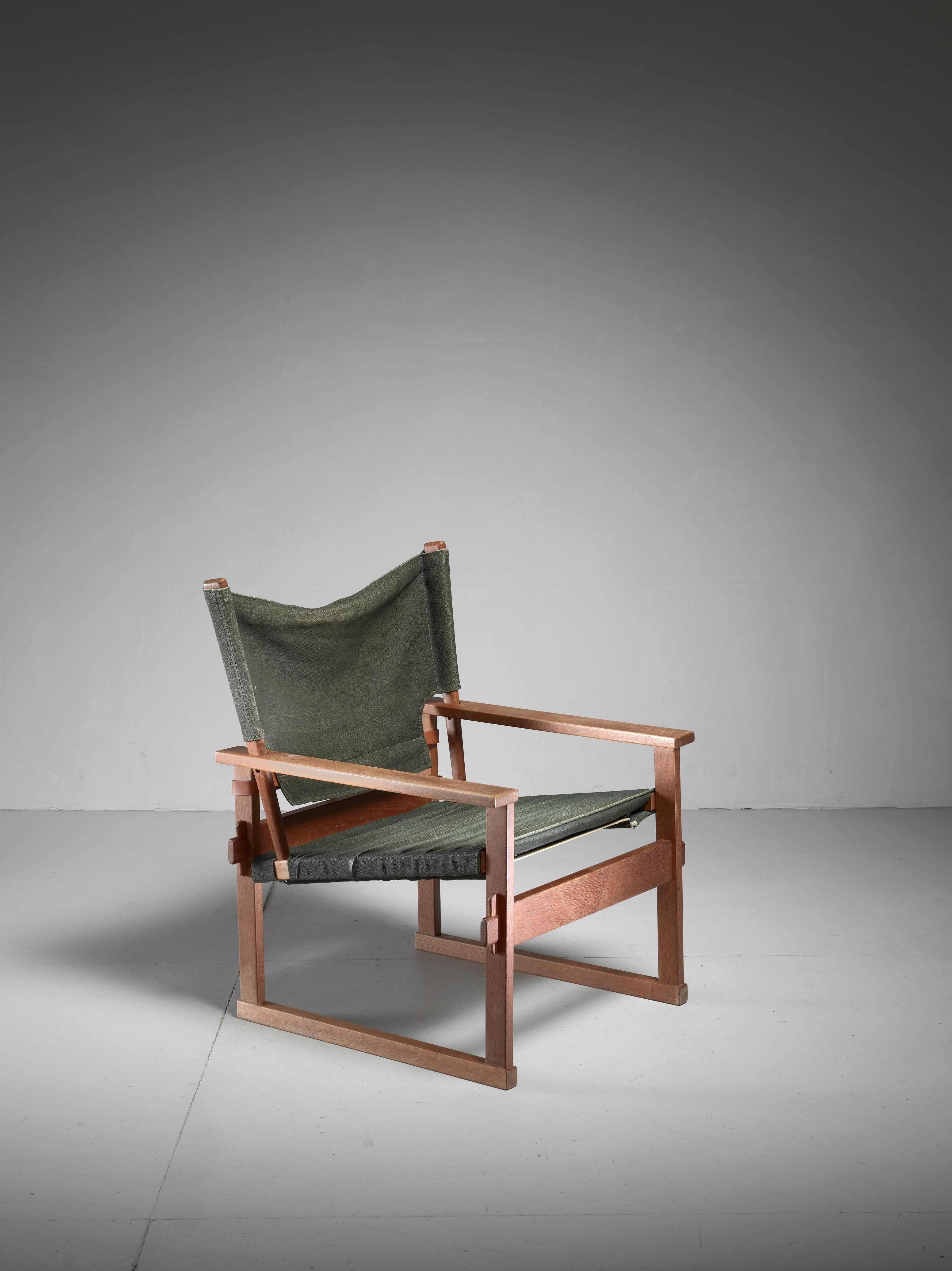 A 'model 60' armchair in oak with a green canvas seat and backrest. The chair was designed in 1961 and produced by Poul Hundevad, Denmark.
It has a beautiful construction using rubber webbing underneath and a leather belt strap at the back to keep