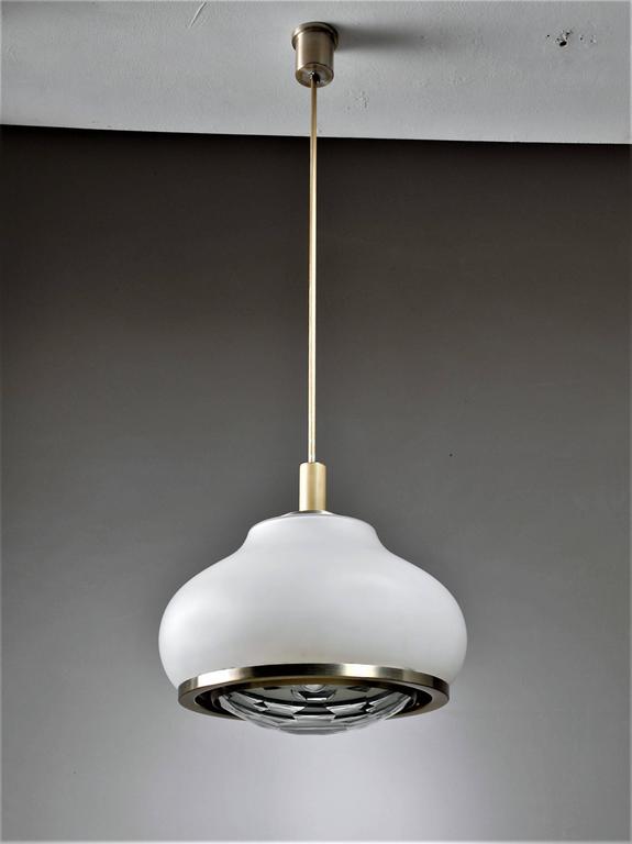 A pendant lamp by Pia Guidetti Crippa for Lumi. White glass shade held by aluminum rings with a facet cut lens for a beautiful light. Two lightpoints per chandelier. 
Labeled on the inside and in a wonderful condition. The total drop can be