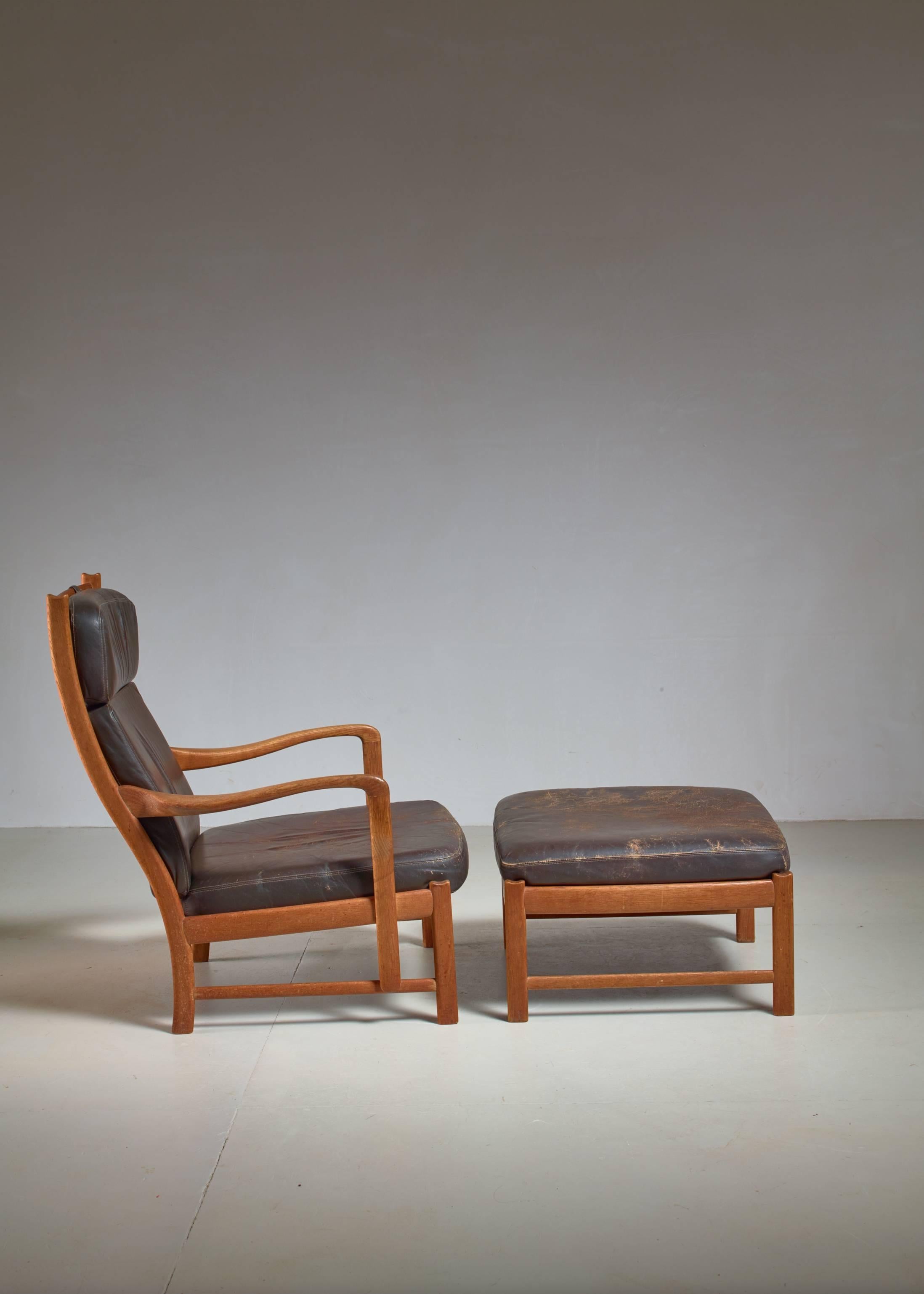 A 1950s Scandinavian lounge chair with a matching ottoman. Both are made of oak with dark brown leather.
The wood is in excellent condition, the leather has some mild wear.
