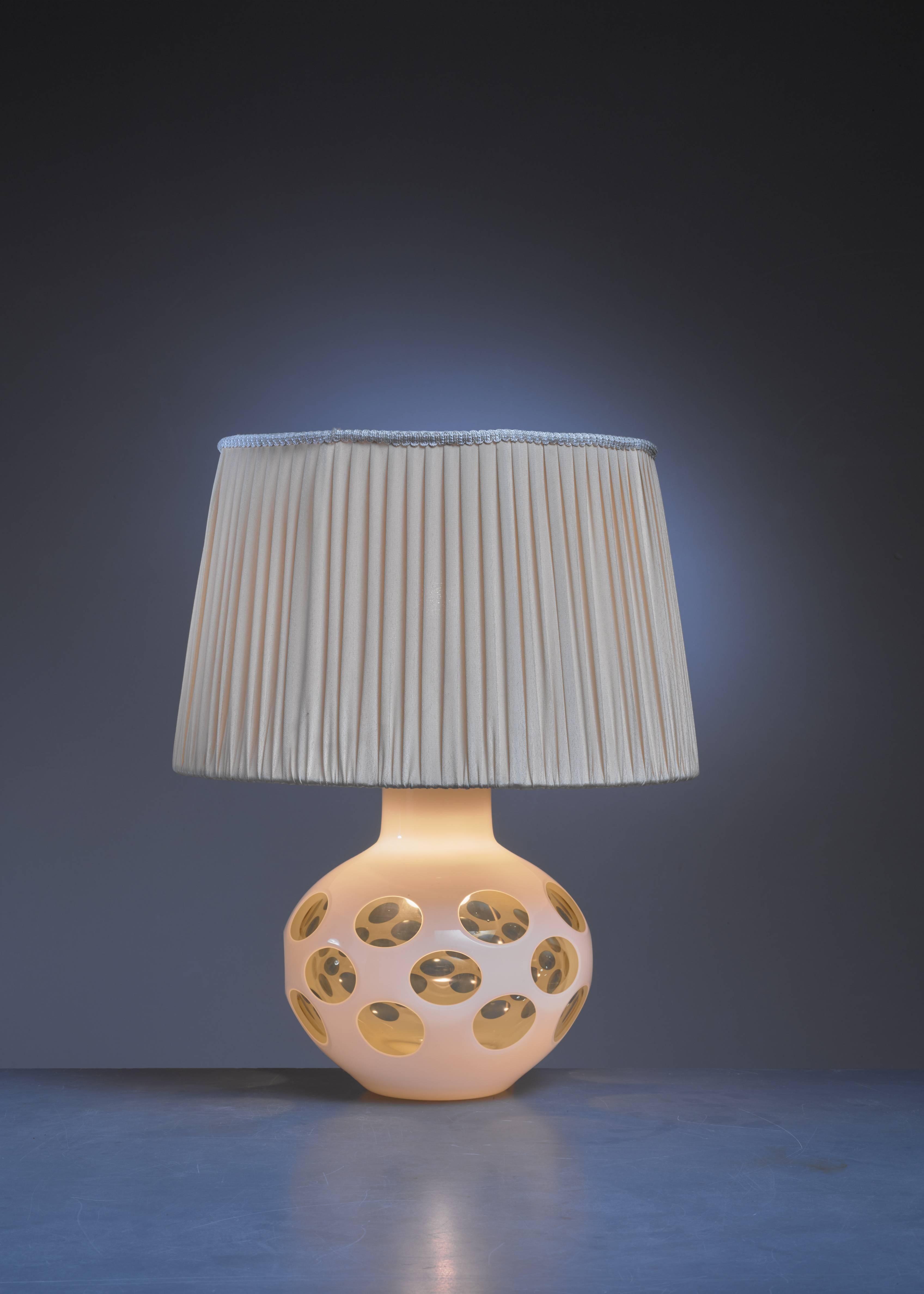 A table lamp by Carlo Nason for Mazzega. The lamp is made of a yellow glass base, painted white with transparent parts, with a brass fitting on top. Inside the base is a small lamp.

The measurements and shipping cost stated are of the lamp without