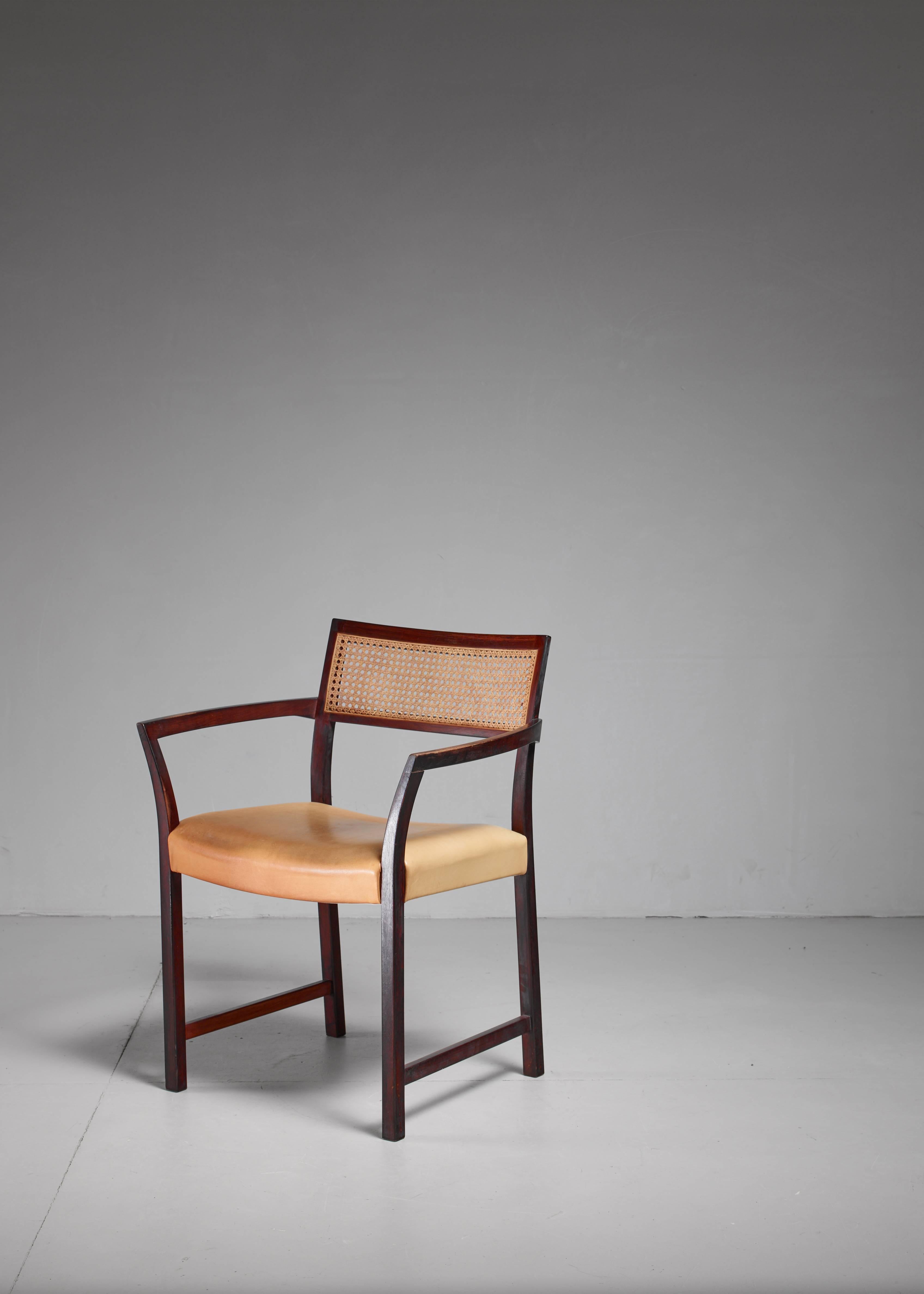 An armchair by Illum Wikkelsø, made of a mahogany frame with a cream colored leather seat and a woven cane backrest. The thin and curving out armrests are a beautiful detail. This chair was a prototype and meant to be part of Wikkelsø's 'Plexus'