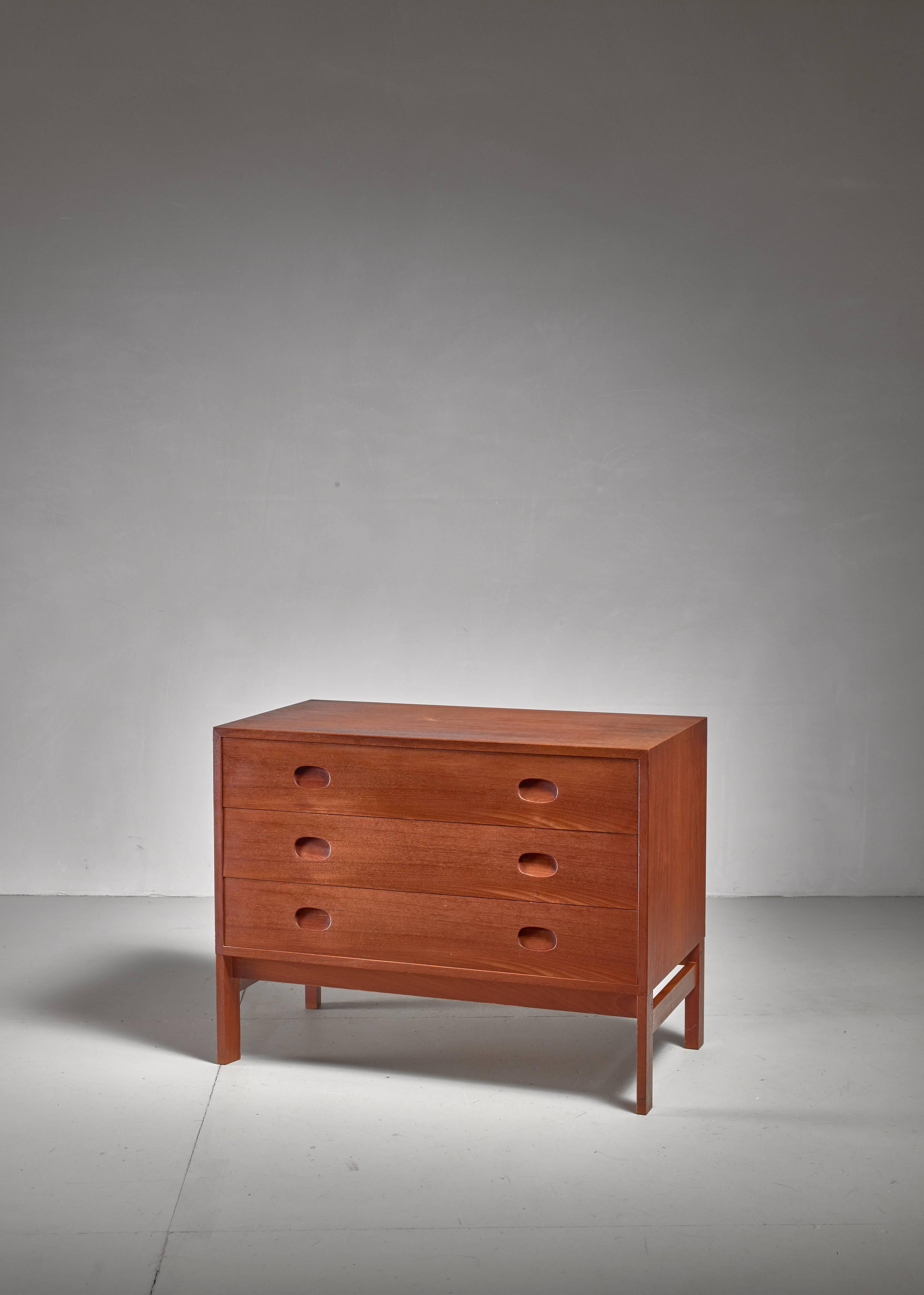 A teak chest with three drawers, in a style reminiscent of Aksel Kjersgaard and Poul Hundevad. The feet can be removed, so it can be placed both on the floor and on top of another chest.