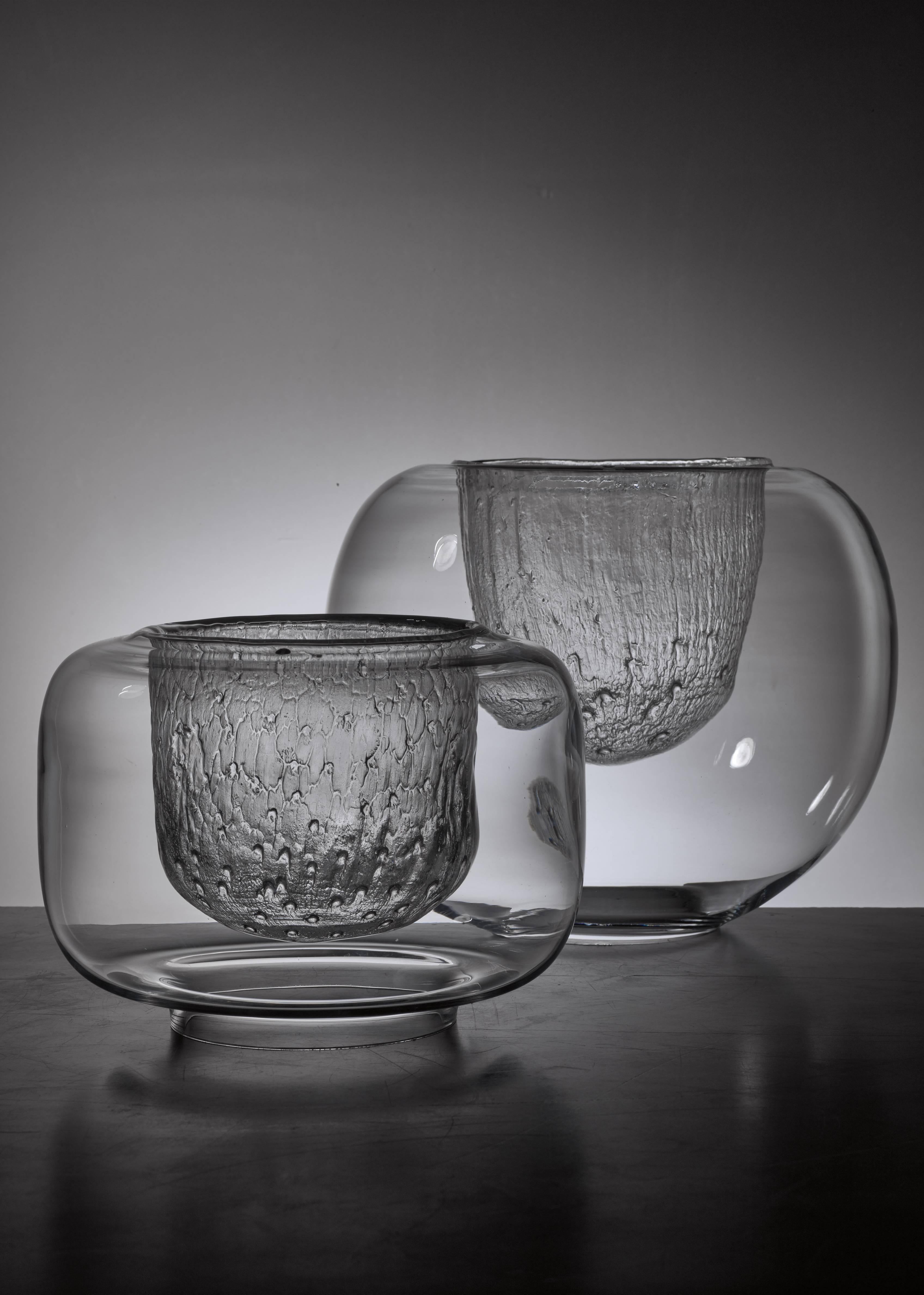 A pair of glass bowls by Timo Sarpaneva for Iittala, Finland. Smooth glass on the outside and ice glass on the inside. These pieces are original Finn Form stock from the 1960s and never used, with labels and in perfect condition. Marked by Sarpaneva