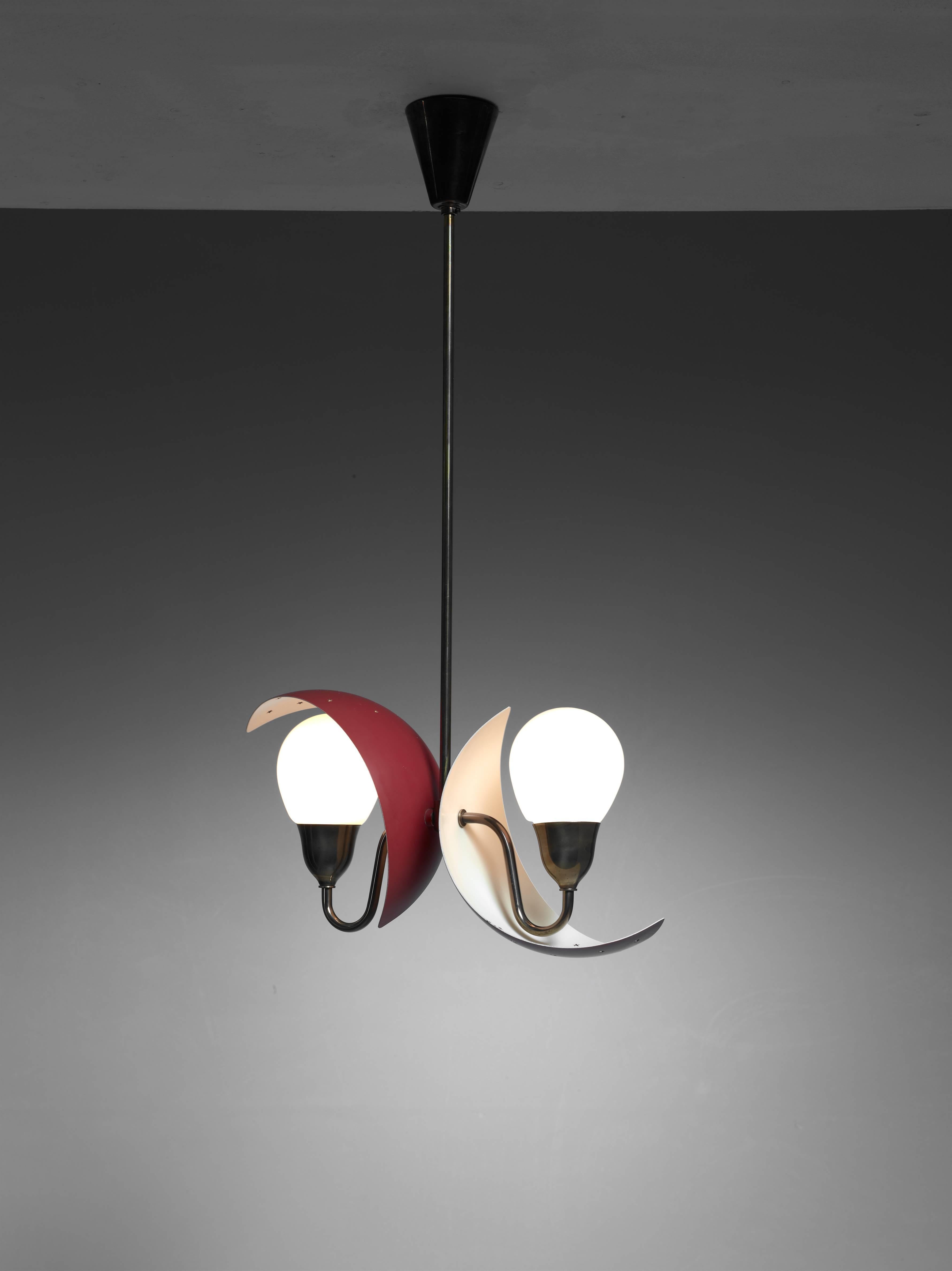 A Bent Karlby attributed pendant lamp for Fog and Mørup, Denmark. The lamp has two crescent shaped dark red metal shades with an opaline glass diffuser each. The shades have star shaped perforations and are adjustable to direct the light according