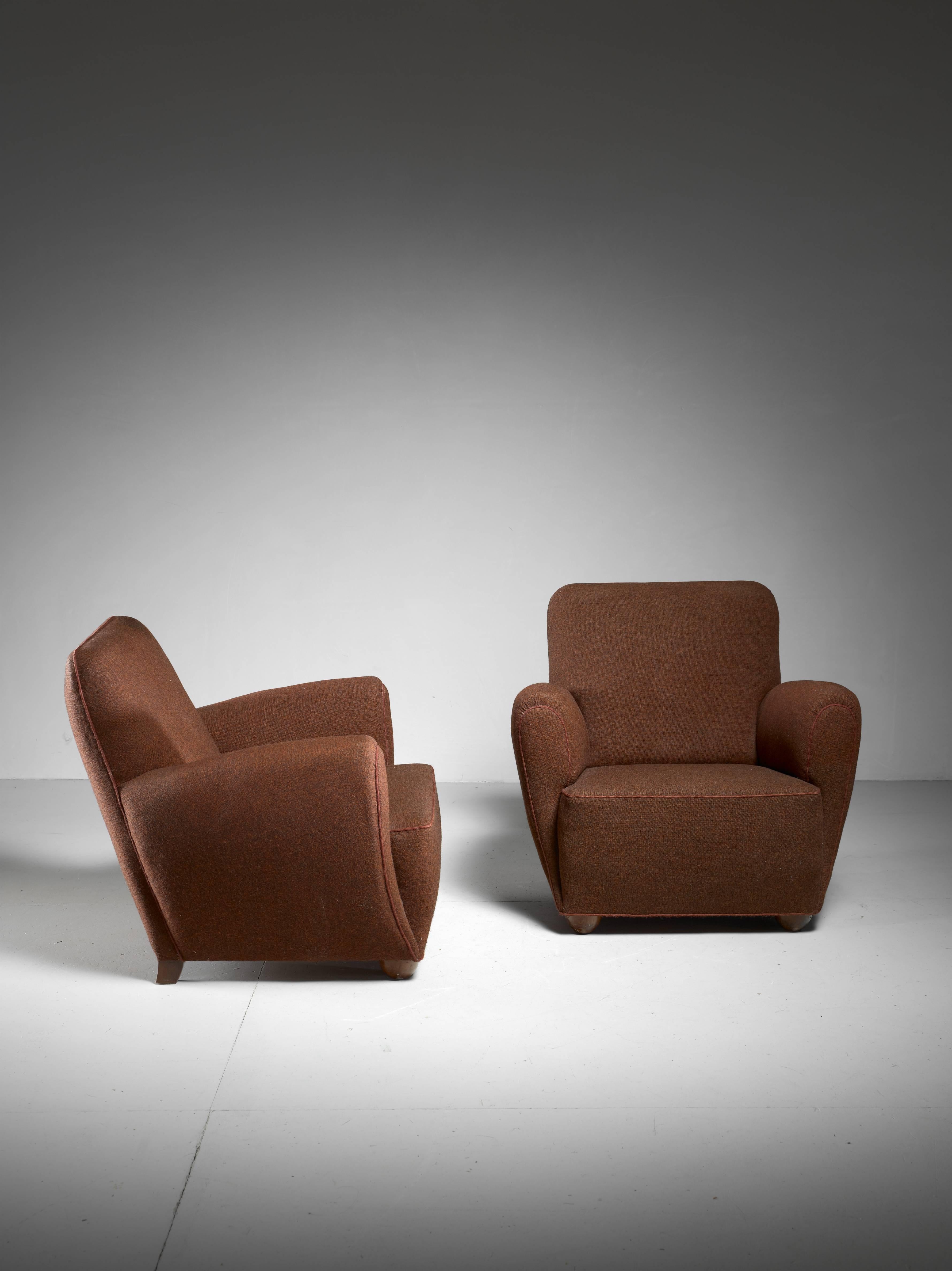 A pair of Danish 1940s lounge chairs with a brown wool upholstery and matching piping, standing on stained beech legs. These comfortable chairs have a beautiful round form.
 