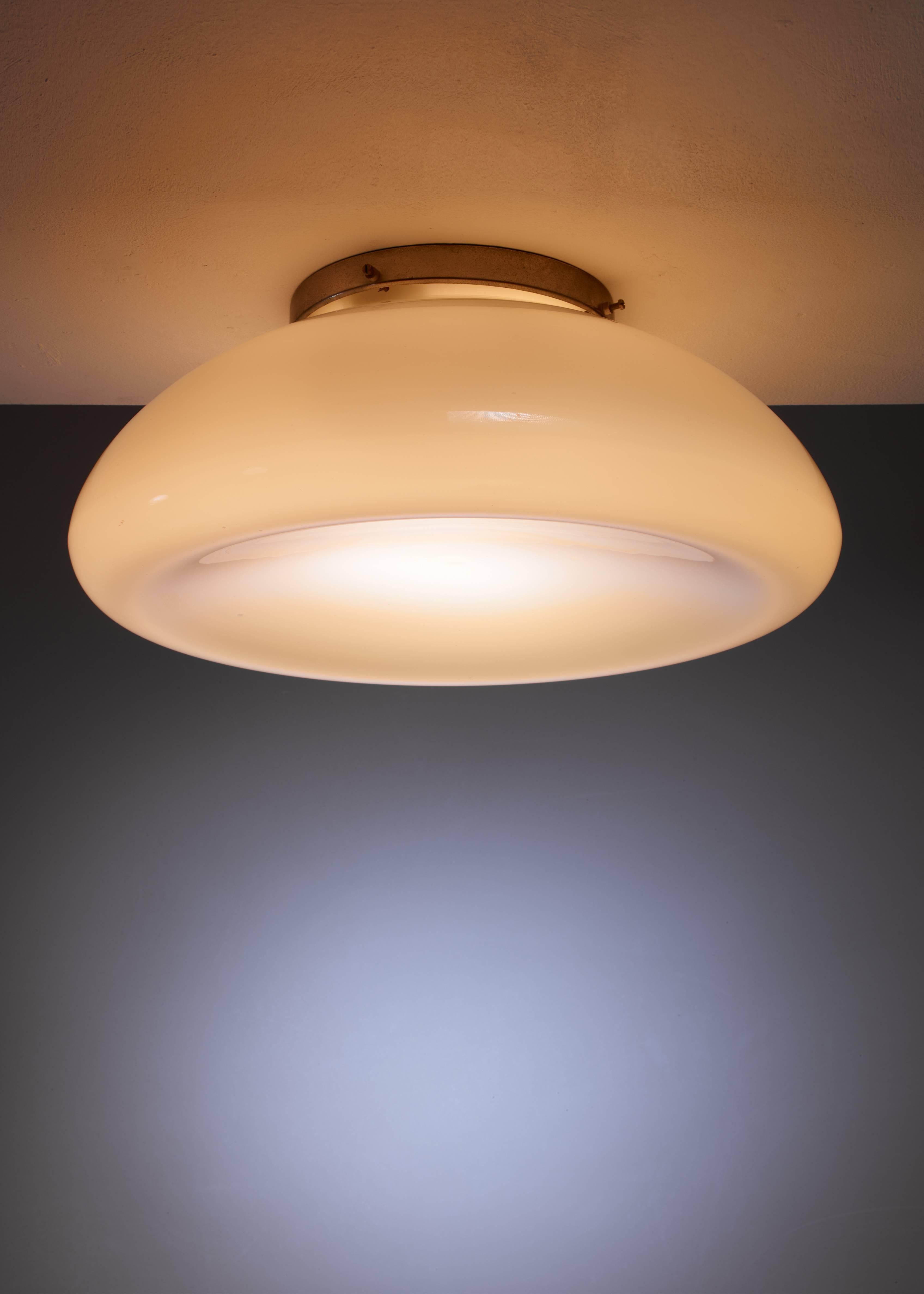 A large and rare Idman flush mount ceiling lamp with a concave round glass shade and three-light bulbs inside. The shade is made of two layers of glass, white inside and yellow on the outside, providing a stunning light effect.

Marked by Idman and