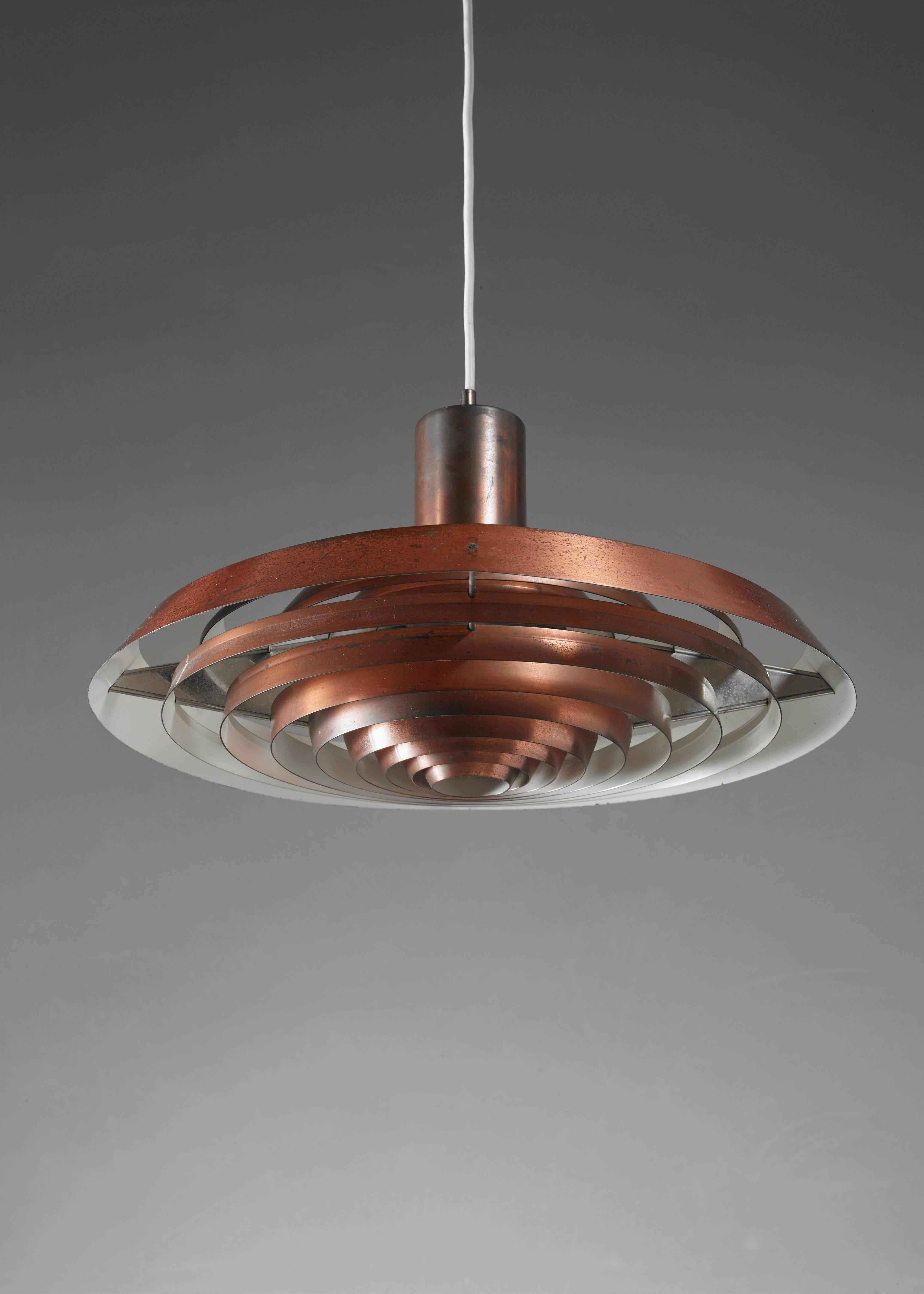 A model 'Tallerken' ('Plate') pendant for Louis Poulsen, Denmark. The lamp is made of concentric circles of copper. It was designed in 1958 by Poul Henningsen for the Langelinie Pavilion in Copenhagen. 

 