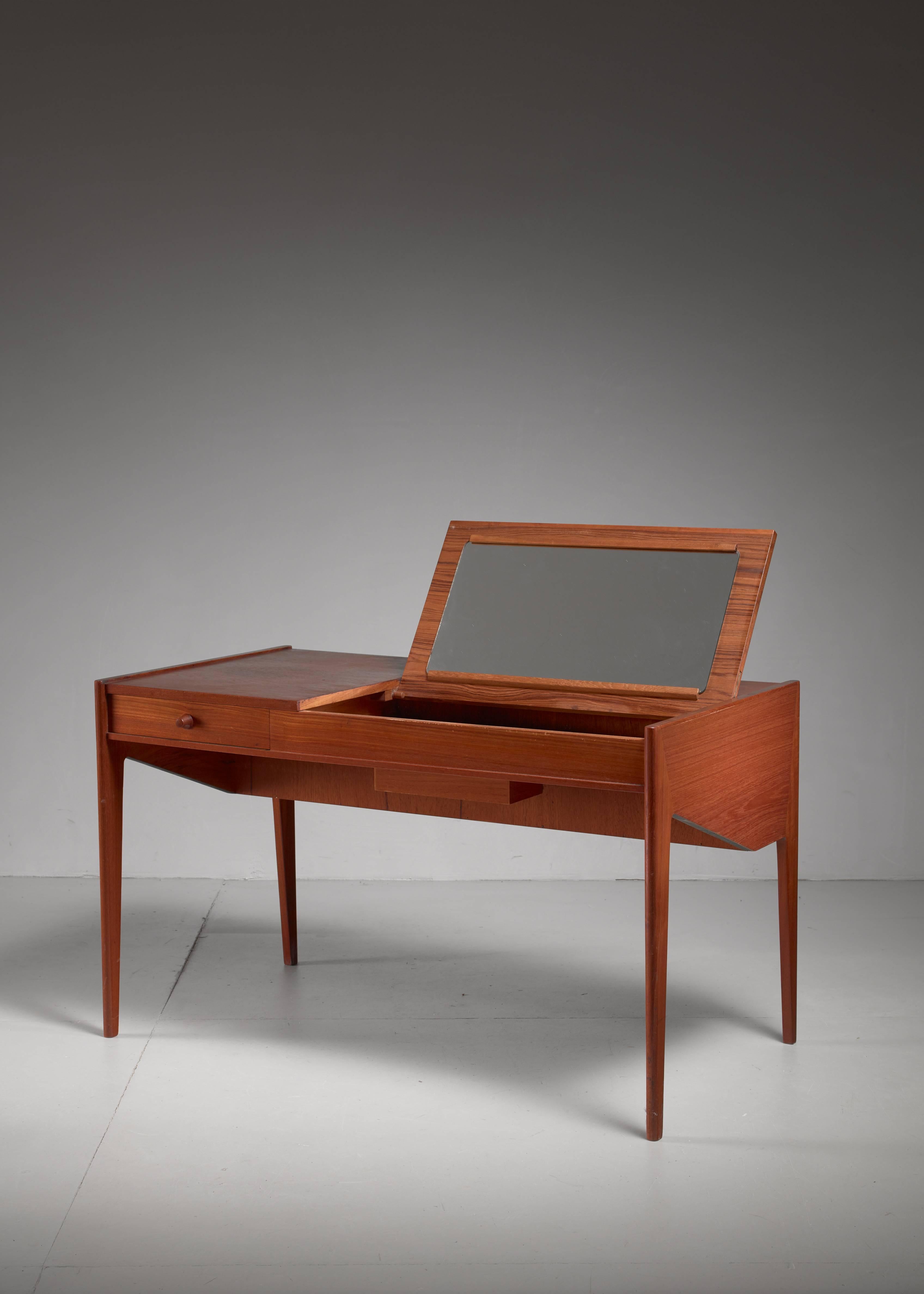 A beautiful teak Aksel Kjersgaard desk and vanity table with a mirror inside and an interior made of oak. Branded underneath.
