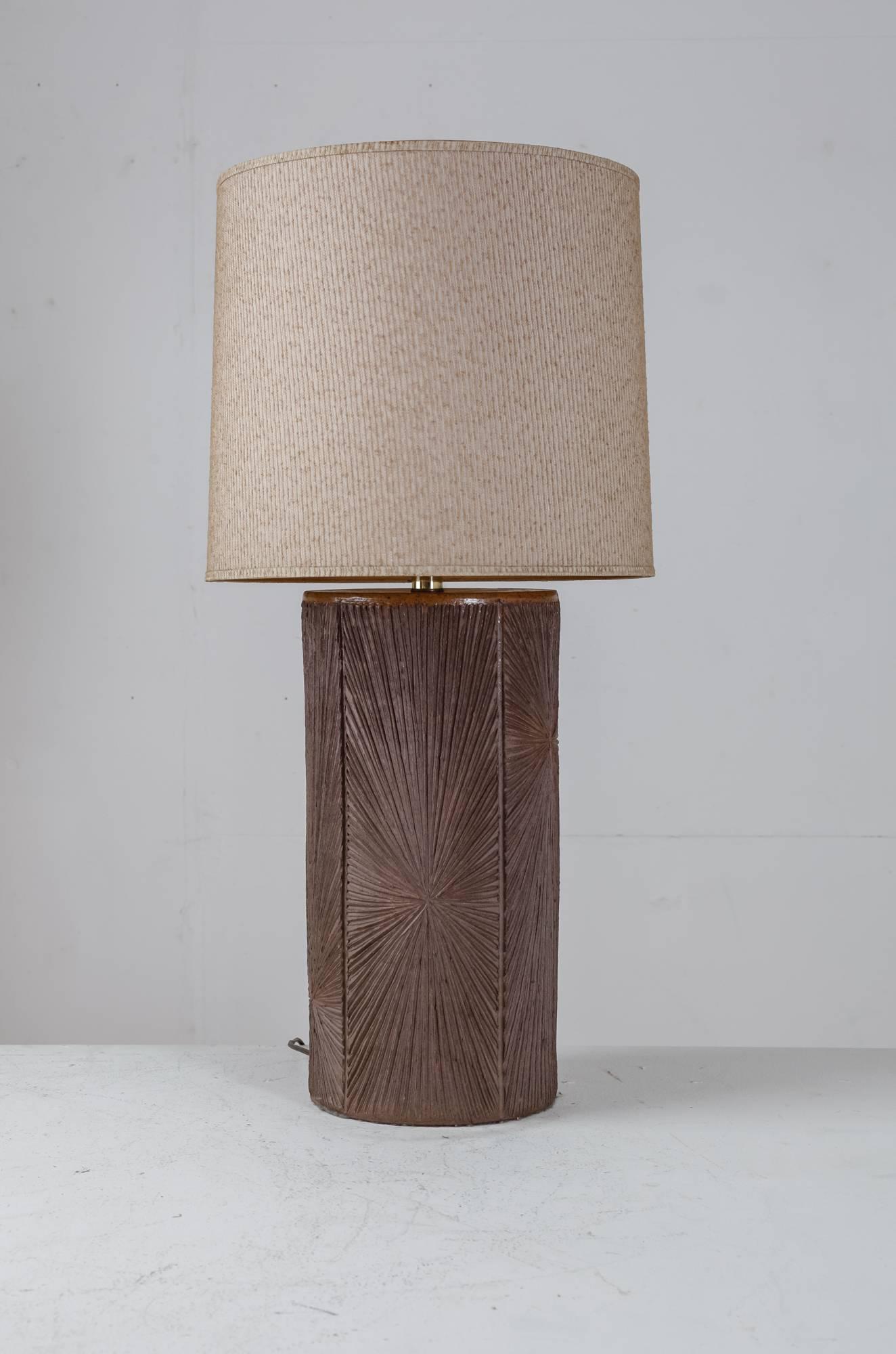 A large cylindrical table lamp made of brown ceramic. The ceramic has been incised with a sunburn pattern.

The measurements and shipping costs stated are of the lamp without shade.