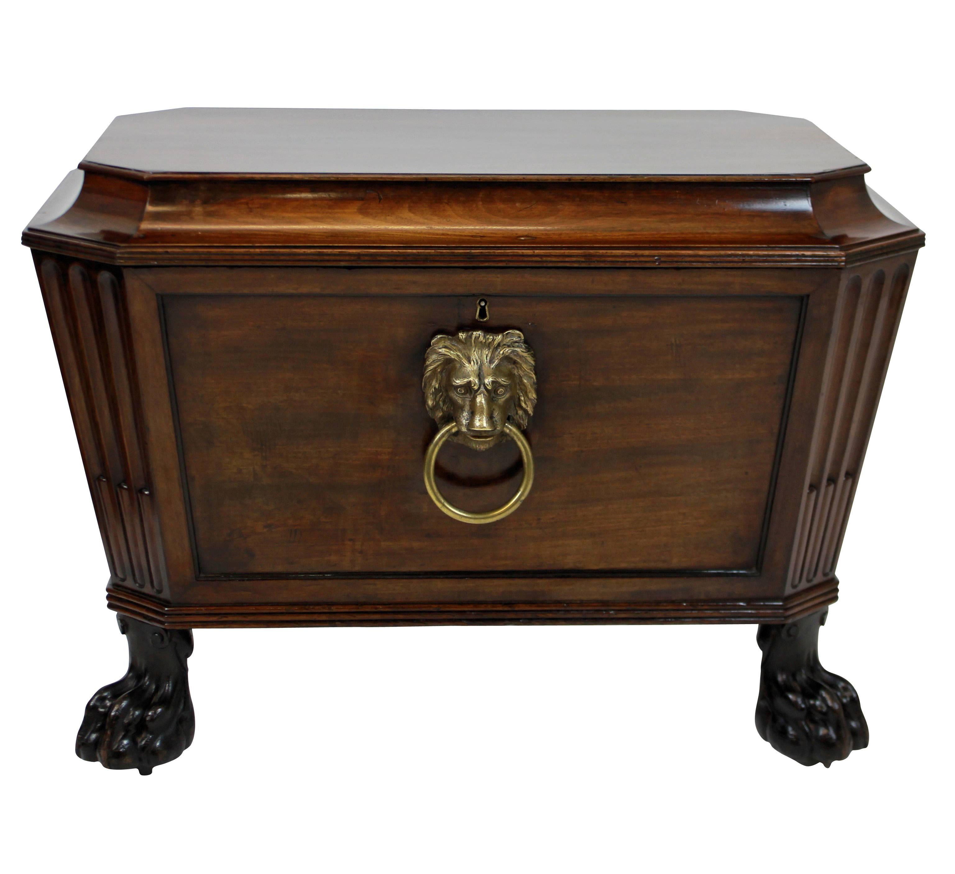 A pair of large English Country House wine coolers or cellarettes in the manner of Thomas Hope. Their quality and condition is rare, given their age. The Cuban mahogany sarcophagus cases are beautifully executed, with lion paw feet and hidden