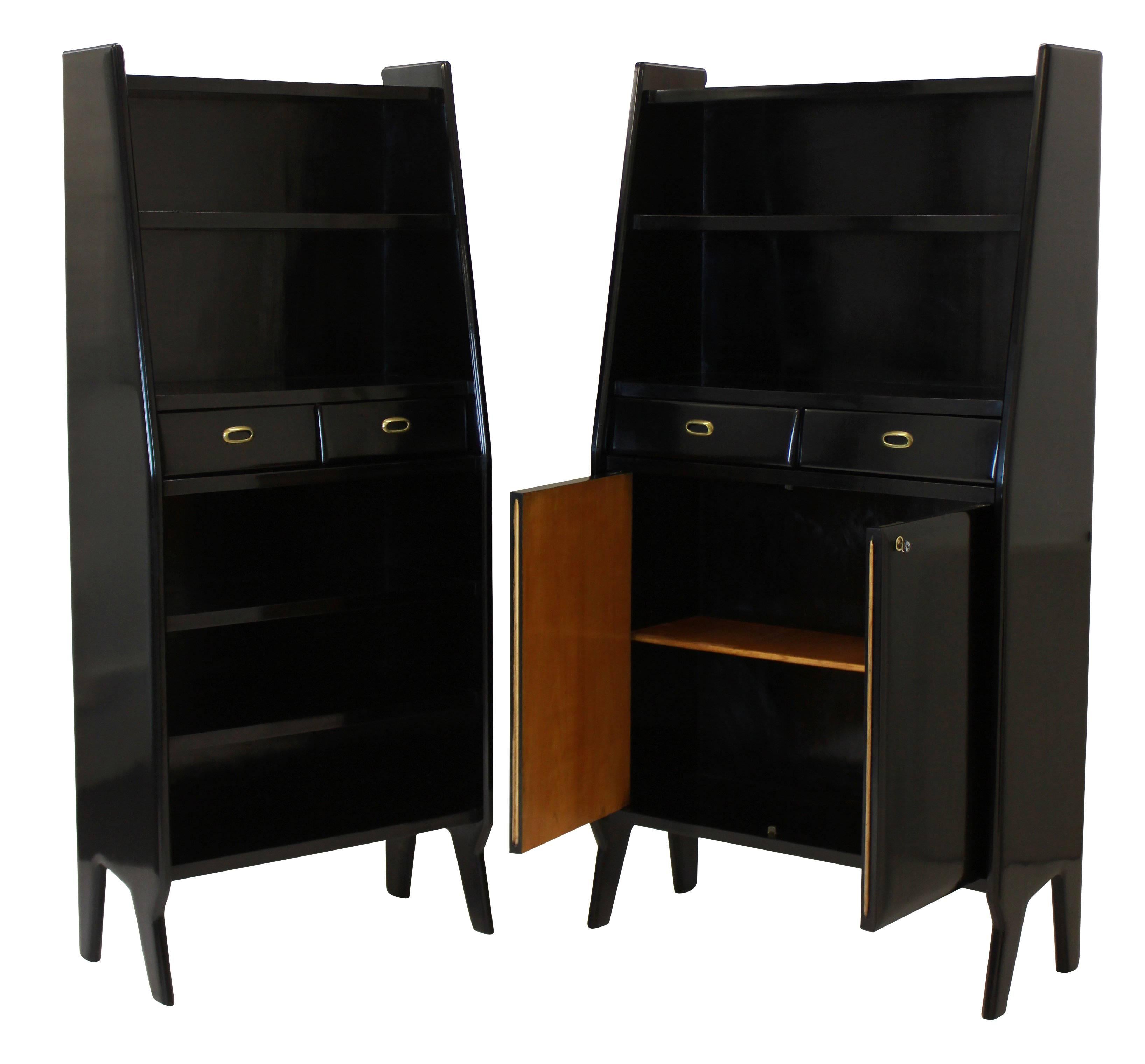 A large pair of stylish Italian bookcases in black lacquered cheerywood, each with shelves, drawers and a lockable cupboard. Of good quality.
  