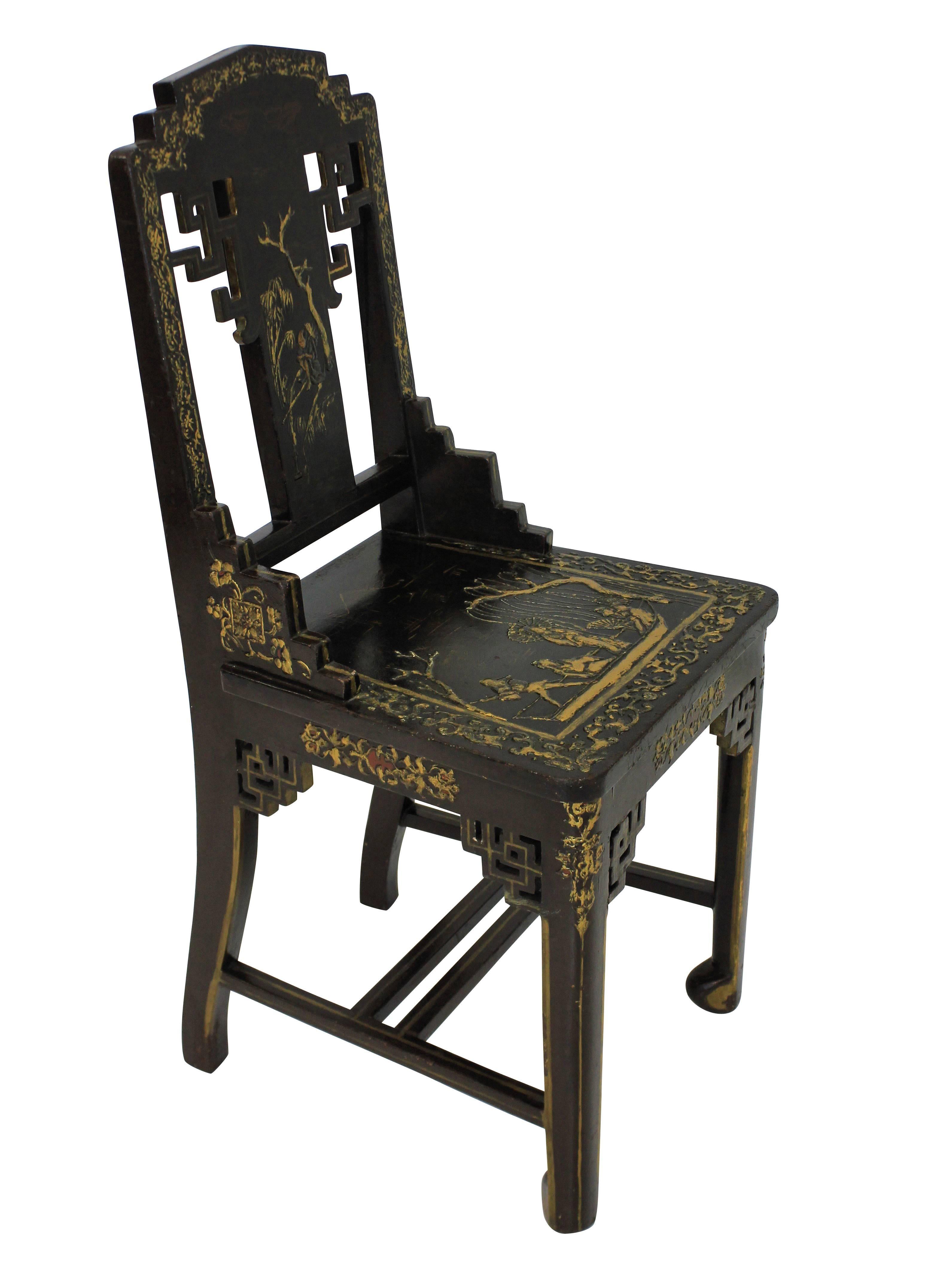 A pair of Chinese chairs in brown lacquer and gold leaf.
    