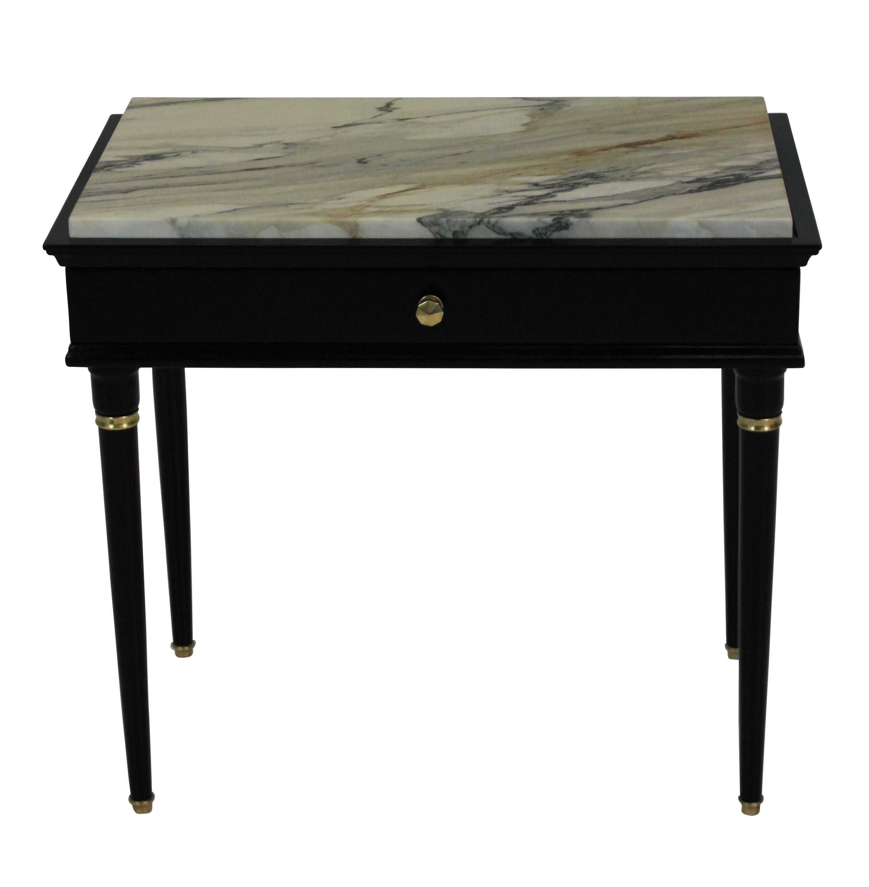 A pair of stylish French Mid-Century nightstands in ebonized wood and brass fittings. With a single frieze drawer and good marble tops.
        