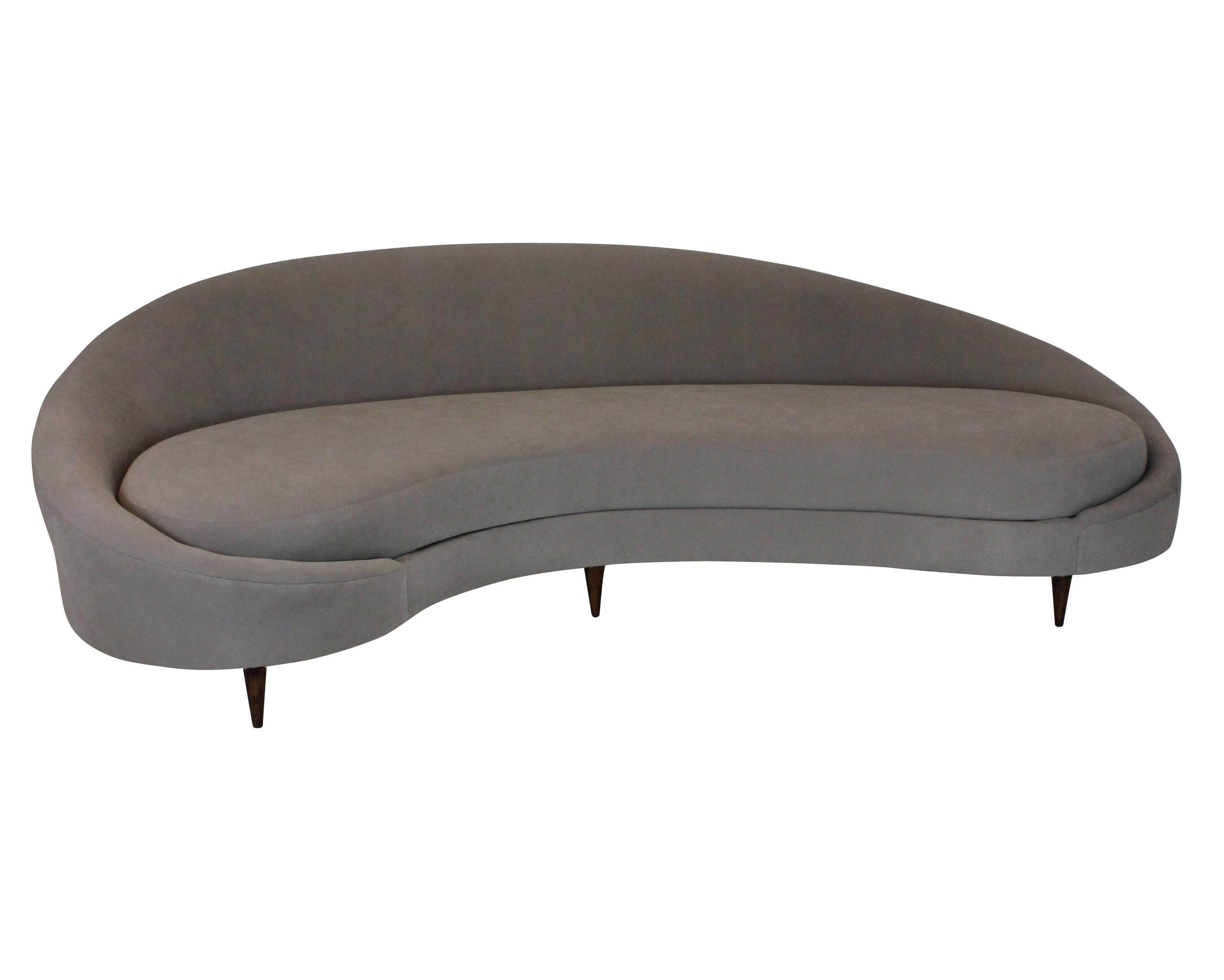 A large sculptural sofa by Ico Parisi of good proportions, upholstered in stone colored faux moleskin, on turned walnut feet.
     