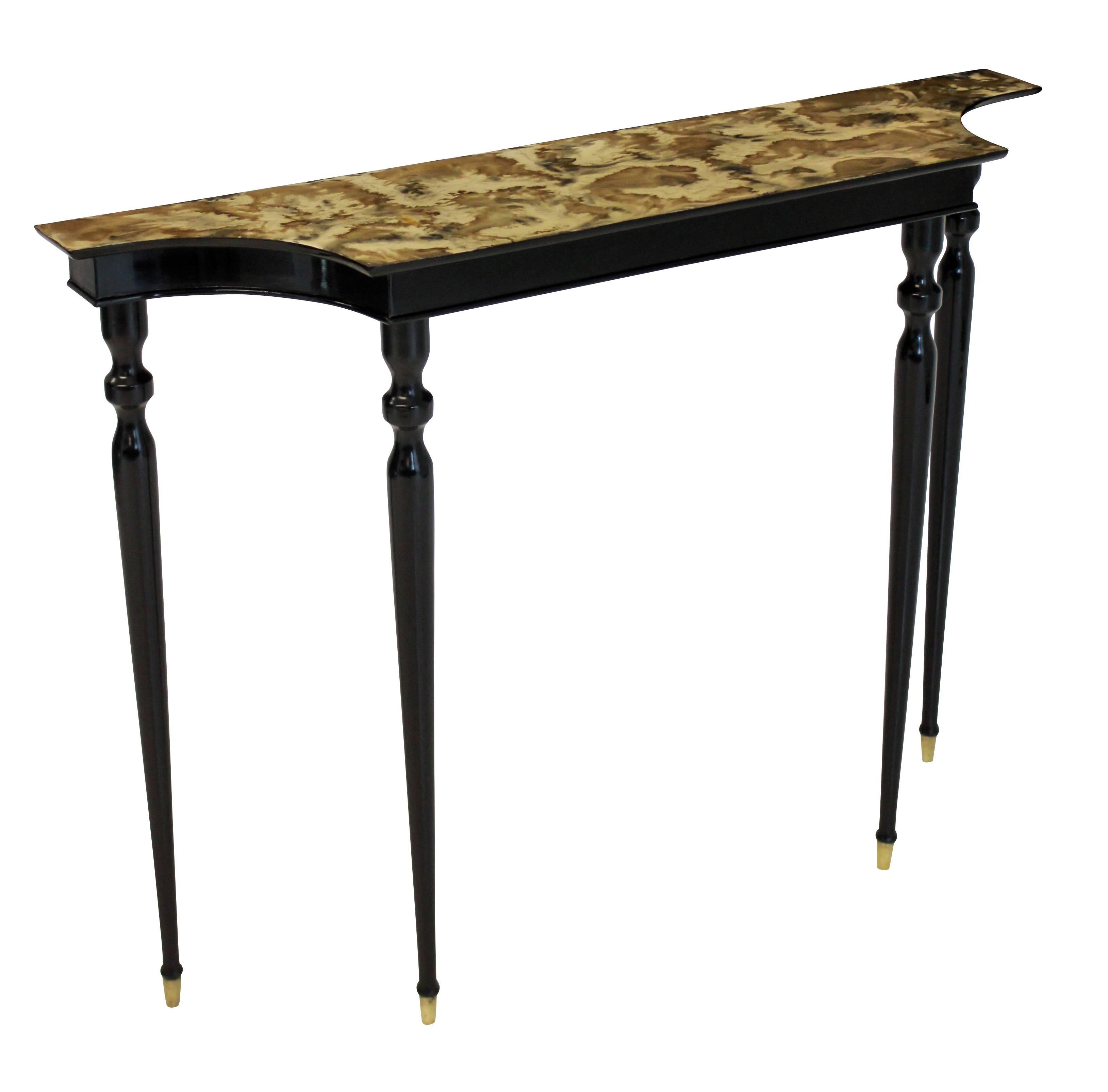 An Italian ebonized console table of Fine proportions, with a serpentine front and a well executed faux marble-top.
 