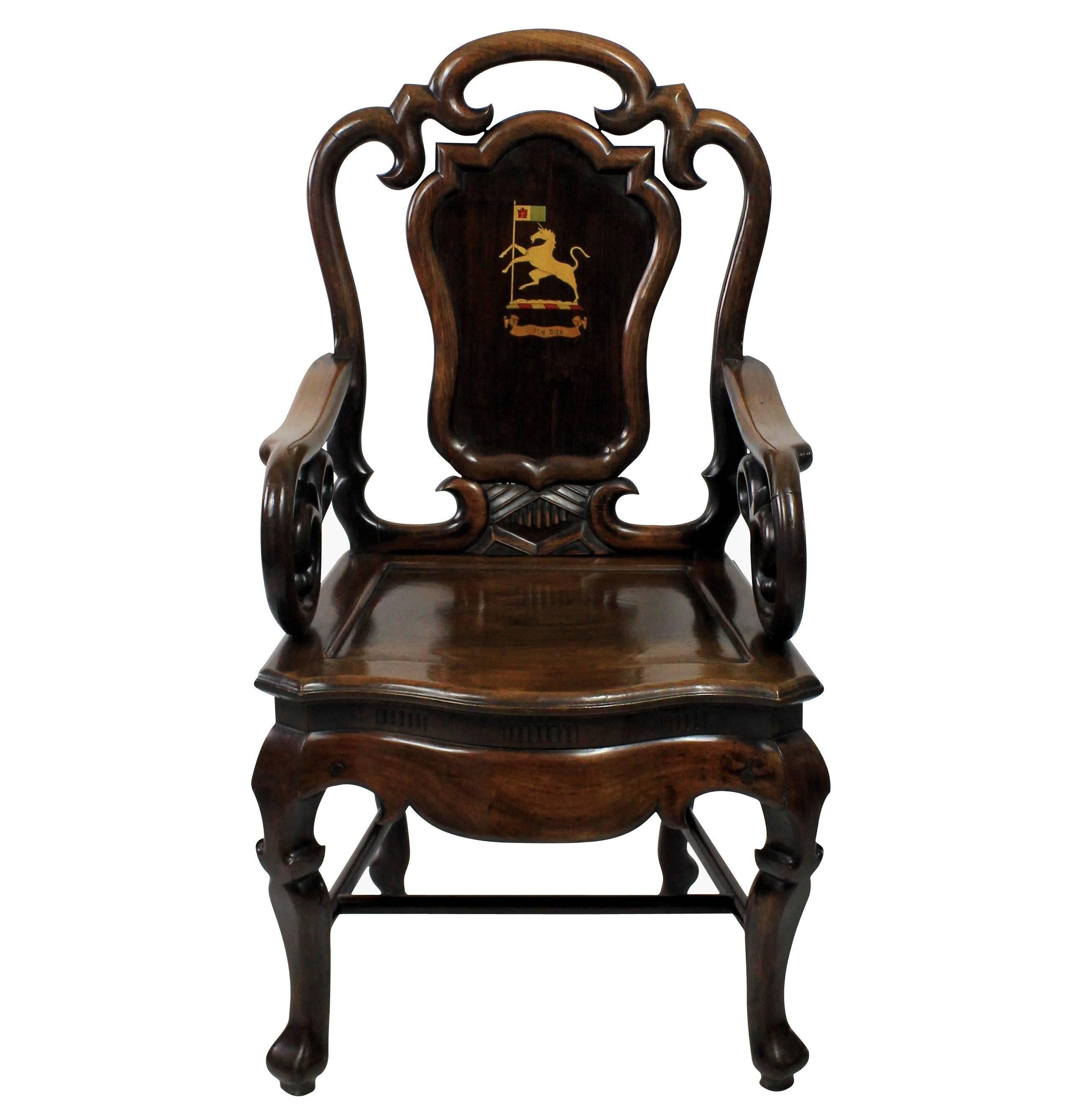 A pair of Anglo Chinese armchairs of fine quality, of unusual design in solid rosewood. Of good heavy weight and bearing an armorial crest associated with a Prince of Wales 'Ich Dien'.
  