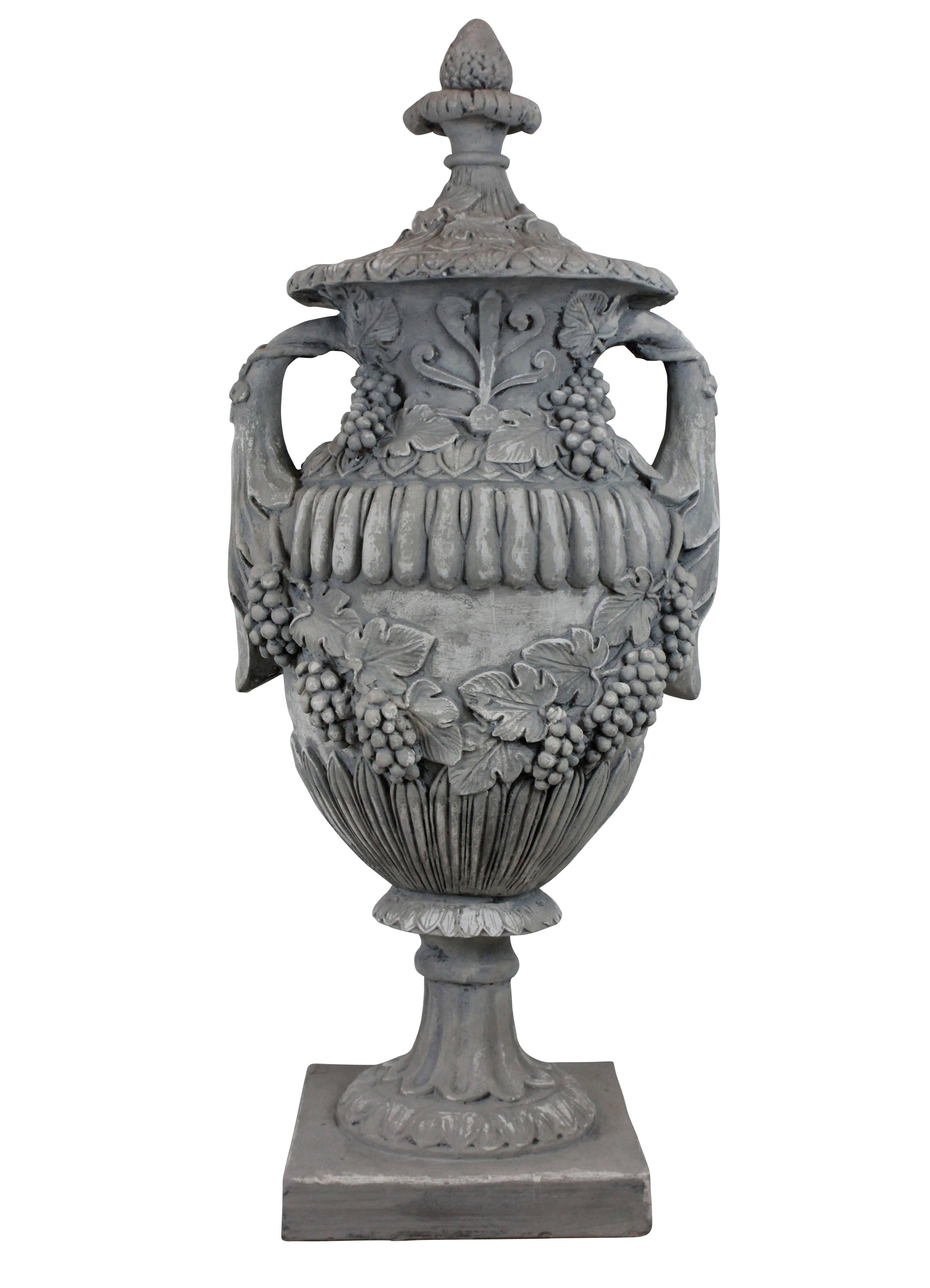 A pair of large English painted plaster urns with lids on antico rouge marble bases. Depicting foliage and grapes.
 