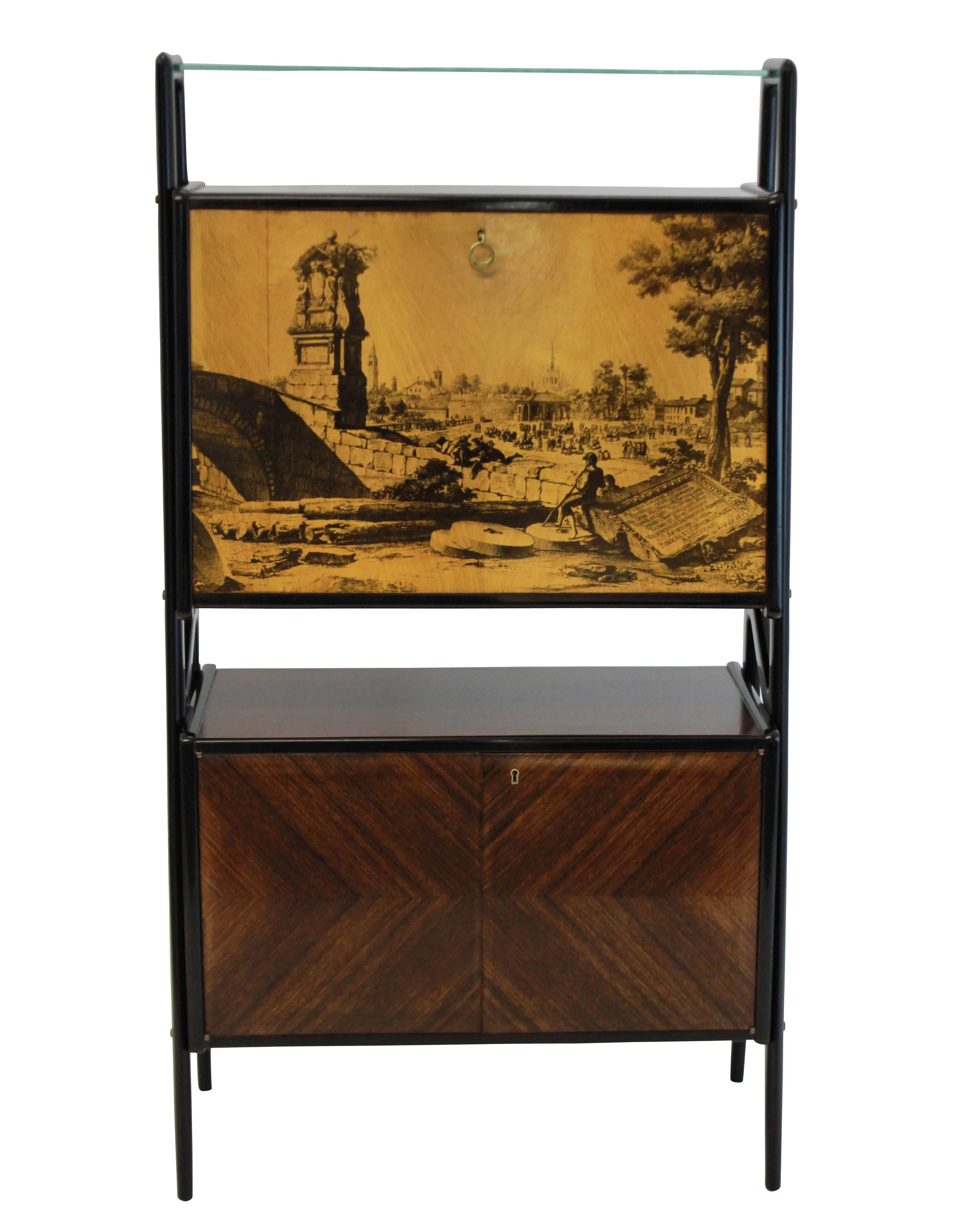 A stunning bar cabinet in the style of Gio Ponti in rosewood with a mirrored bar compartment above with a lacquered fall front door depicting a classical scene. A lockable compartment below lined in birch.\
     