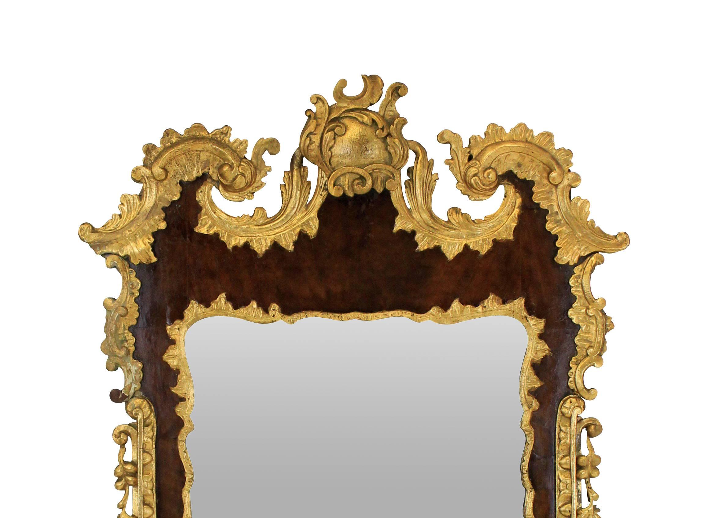 A fine English George III style walnut and parcel gilded mirror, with its original bevelled mirror plate.
